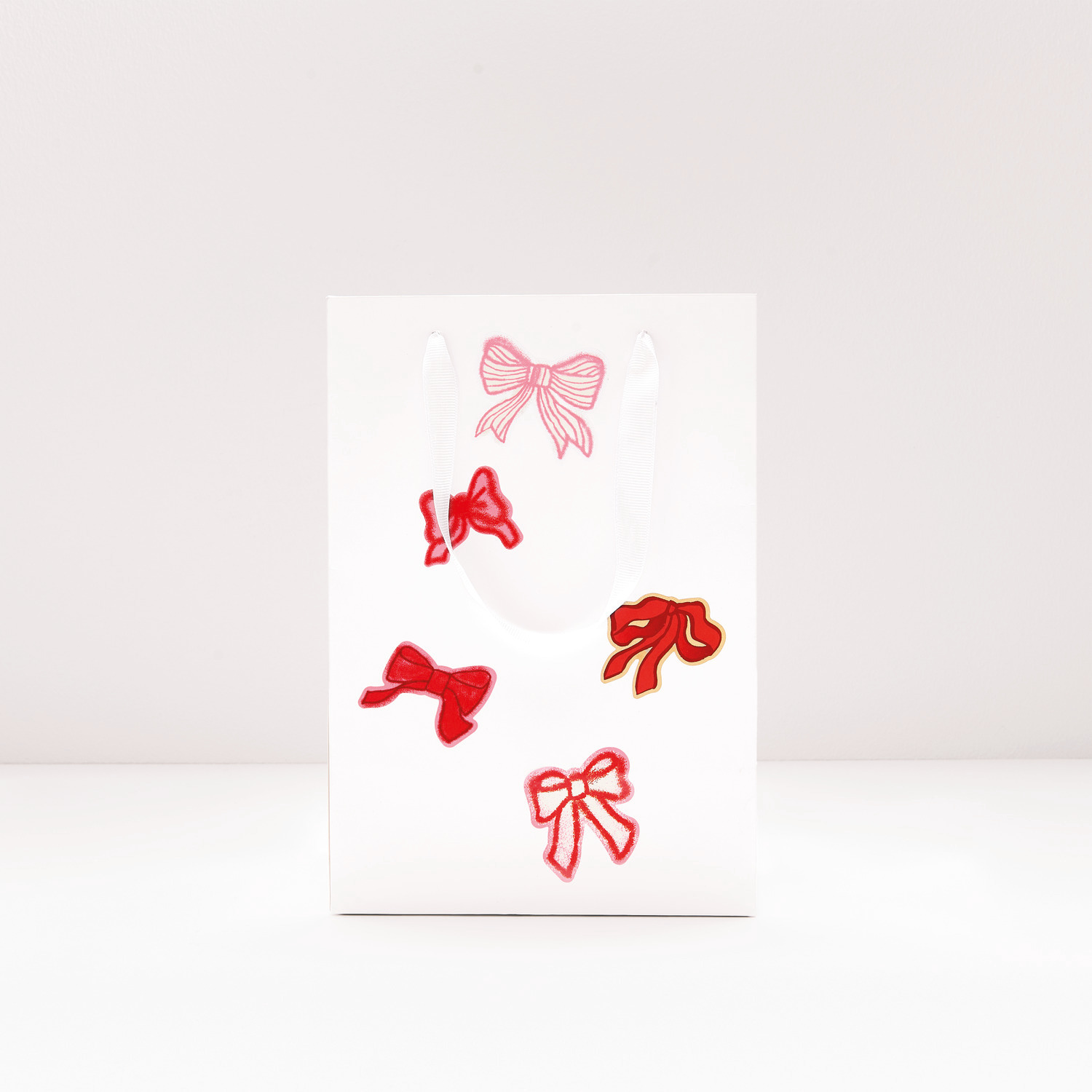 Paper Poetry Sticker Schleifen Classic, rote Schleifen auf weißem Hintergrund, 100 Stück Ø 5cm. Ideal für kreative Bastelprojekte.