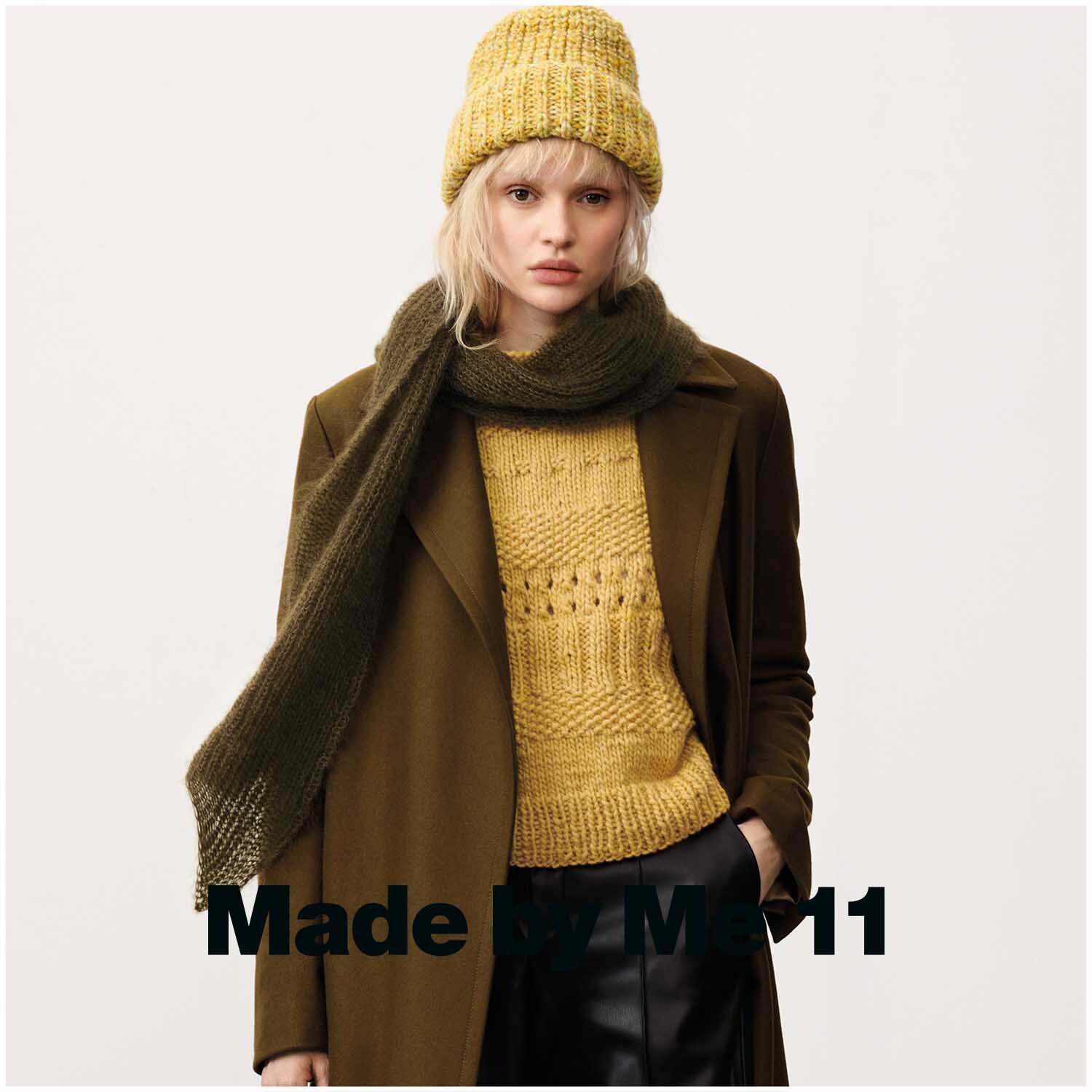 Essentials Super Kid Mohair Loves Silk: Frau in olivgrünem Schal und Mütze, gelbem Pullover, braunem Mantel. Perfekt für stilvolle Wintermode.
