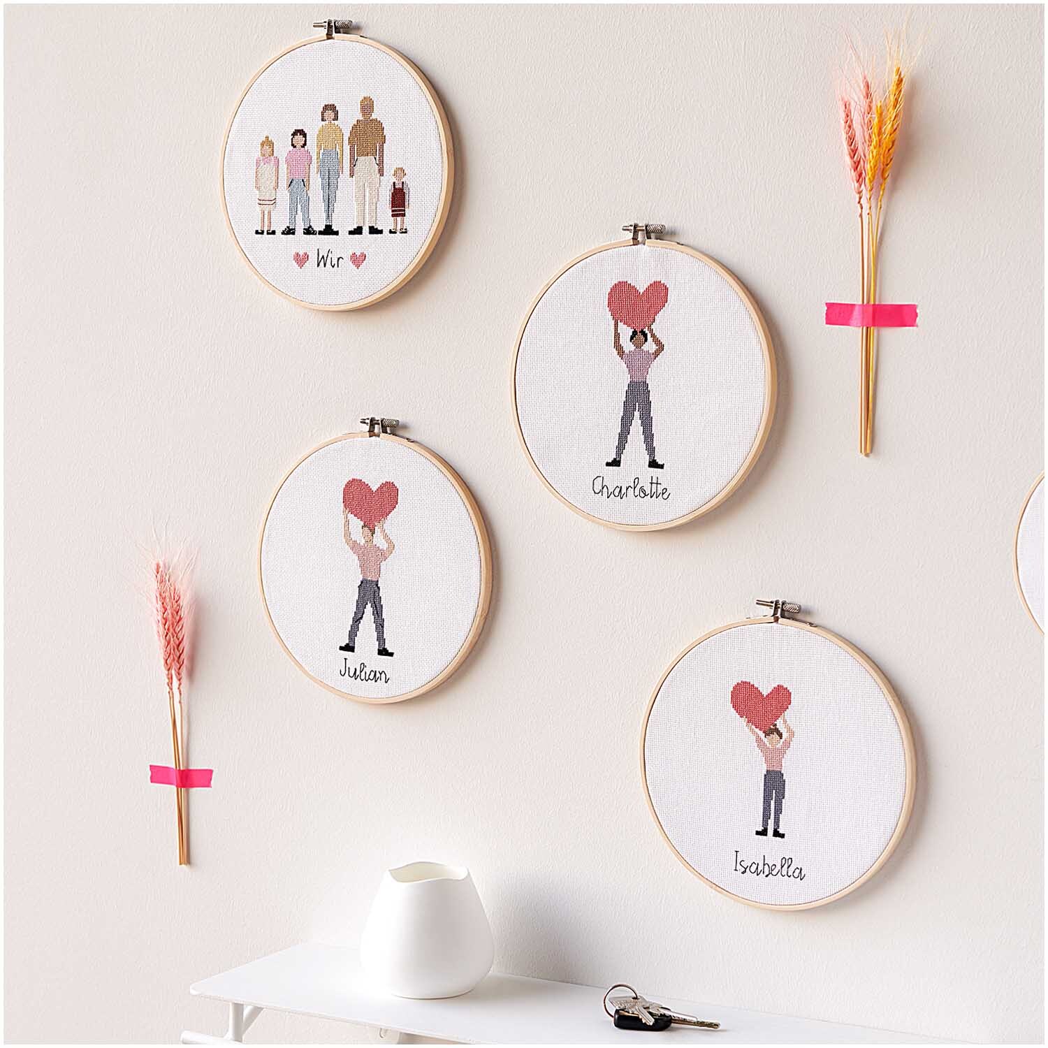 Figurico Stickpackung You Rock My World 20cm zeigt gestickte Figuren mit Herzen in Holzrahmen an der Wand.
