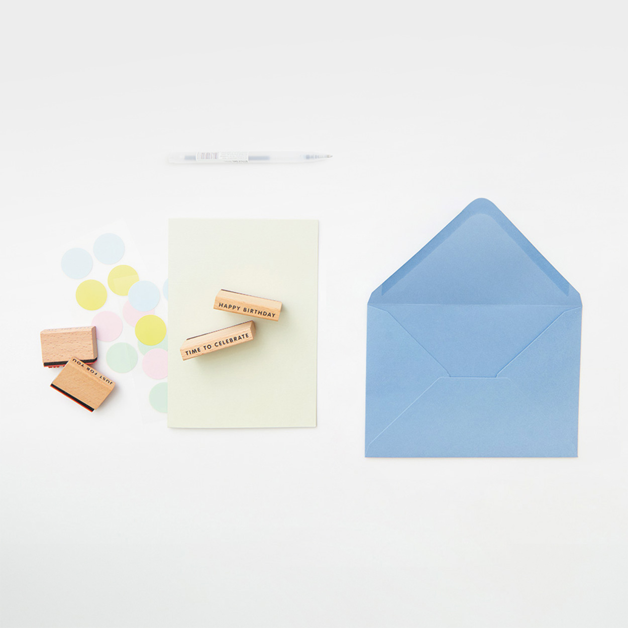 Ein blauer Umschlag und eine hellgrüne Karte mit vier Stempeln und Stickern. Produkte aus der Serie Paper Poetry Basic.