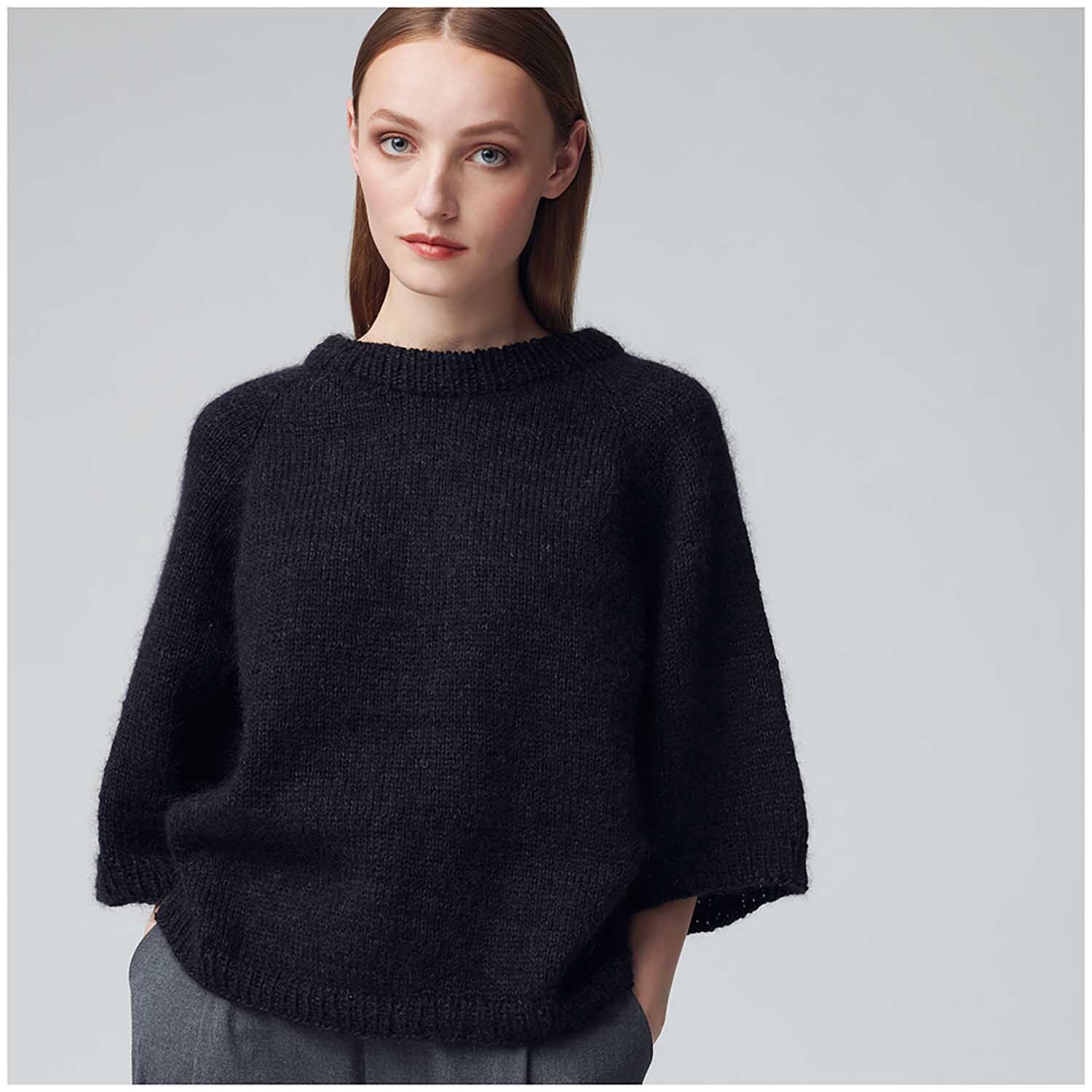 Essentials Super Kid Mohair Loves Silk: Frau trägt schwarzen Pullover aus weichem Mohair-Seide-Gemisch von Rico Design.