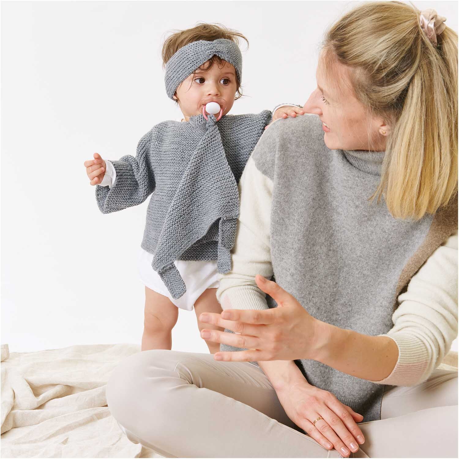 Rico Baby Classic dk: Mutter und Kind in gestrickten, silbernen Outfits aus weicher Wolle.