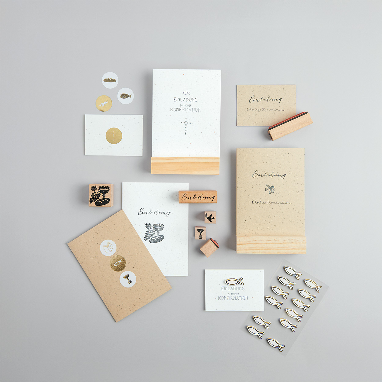 Karten in mehreren Farben und mit unterschiedlichen Designs, dazu passende Stempel, Sticker und Kartenhalter aus Holz. Flatlay von Produkten.