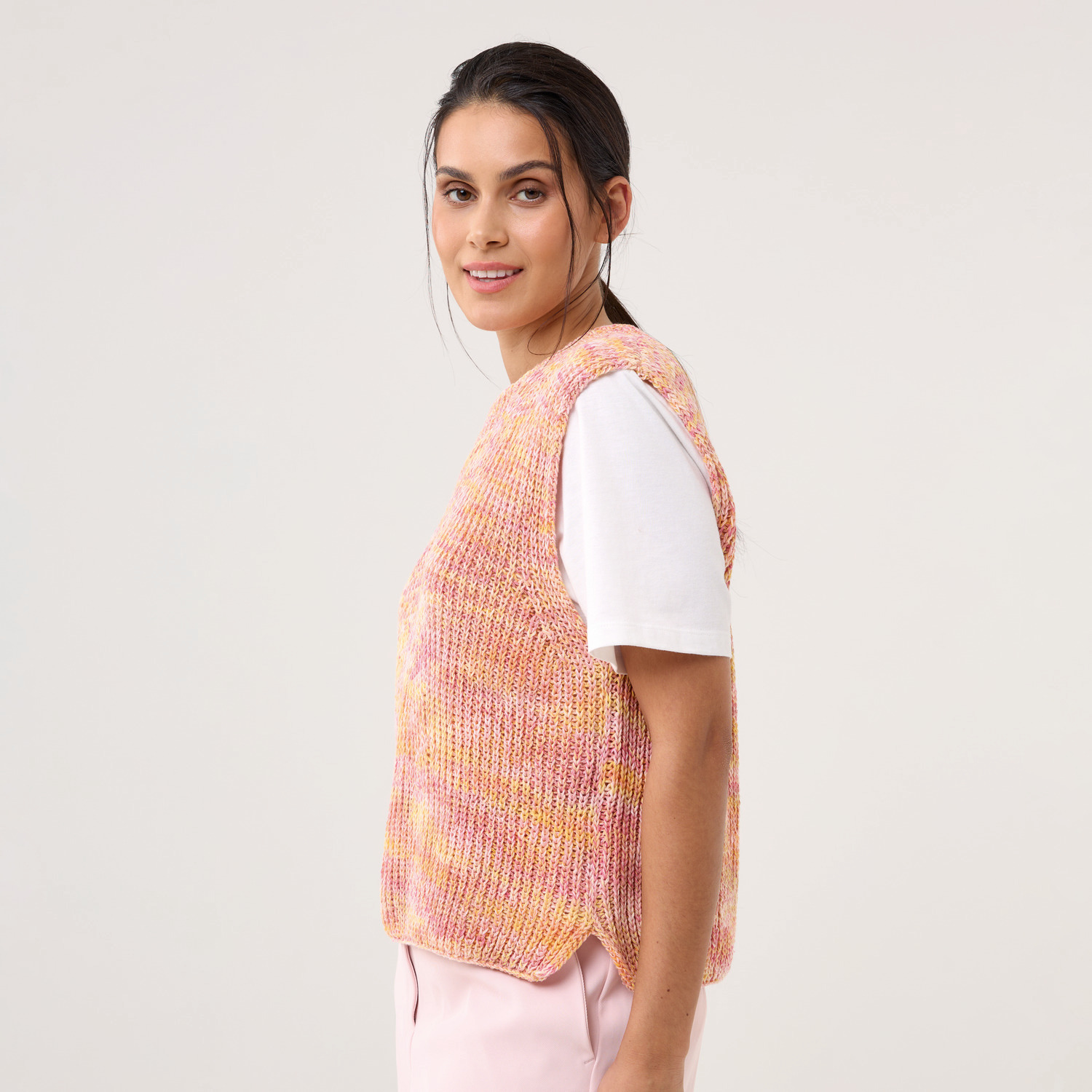 Strickset Pullunder Modell 05: Frau trägt einen pastellfarbenen Pullunder über einem weißen T-Shirt.
