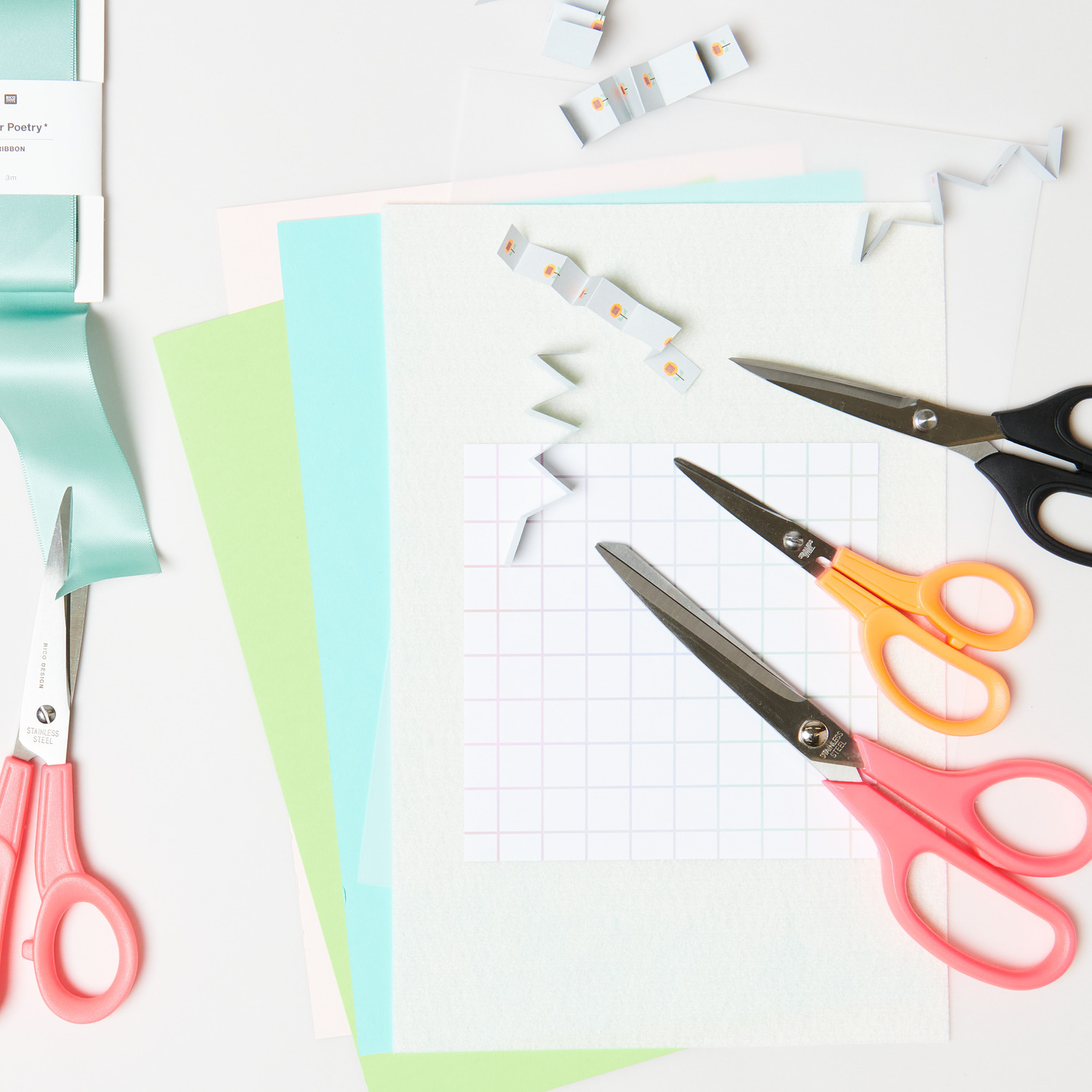 Universalschere Premium: Verschiedene Scheren in Neonfarben auf Bastelpapier, ideal für kreative Projekte.