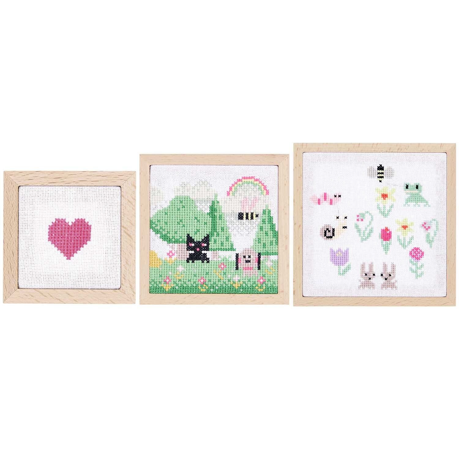 Dekorahmen quadratisch Set: Drei Holzrahmen mit bunten Stickmotiven, darunter Herz und Tiere.