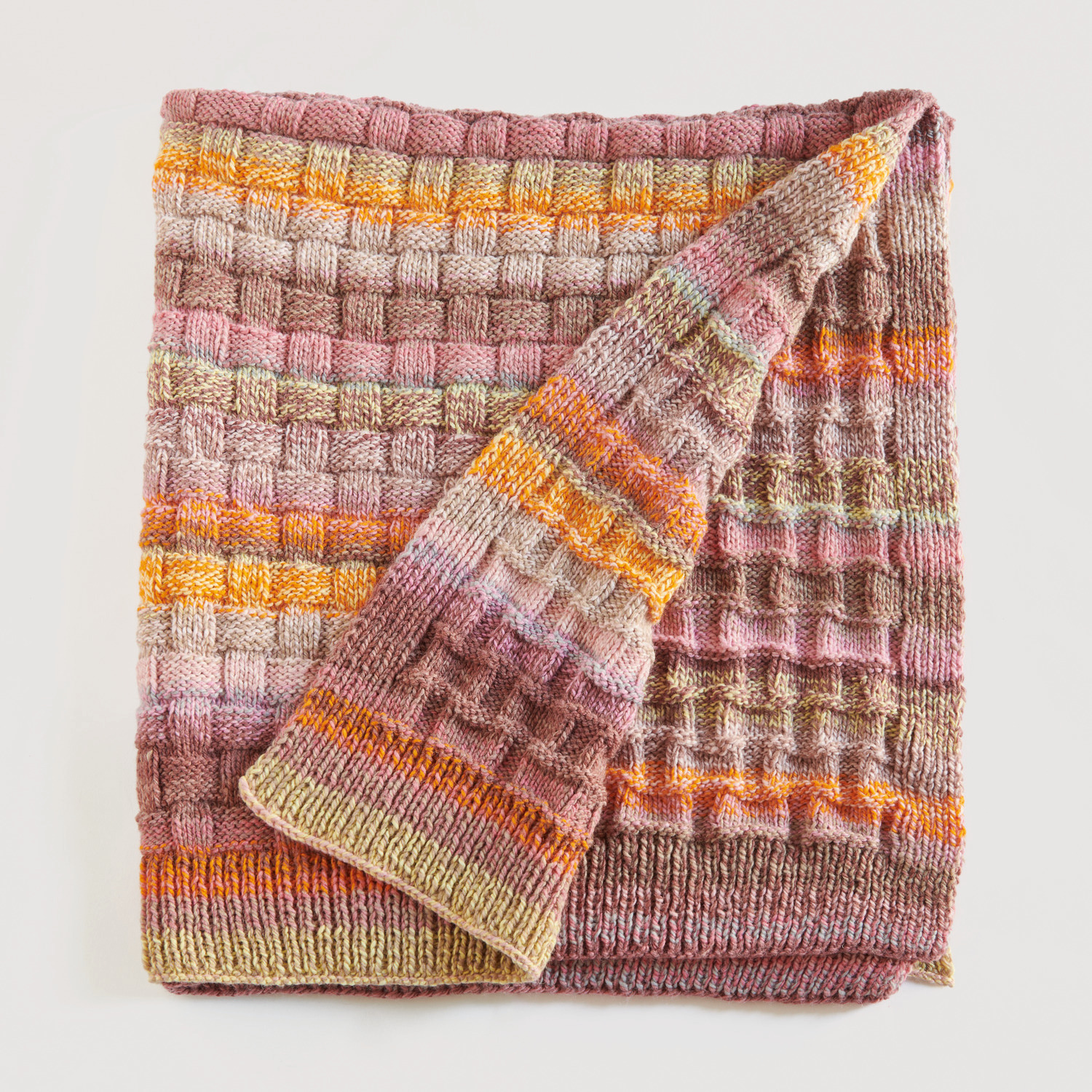 Bunte Decke auf grauem Hintergrund – zum Strickset