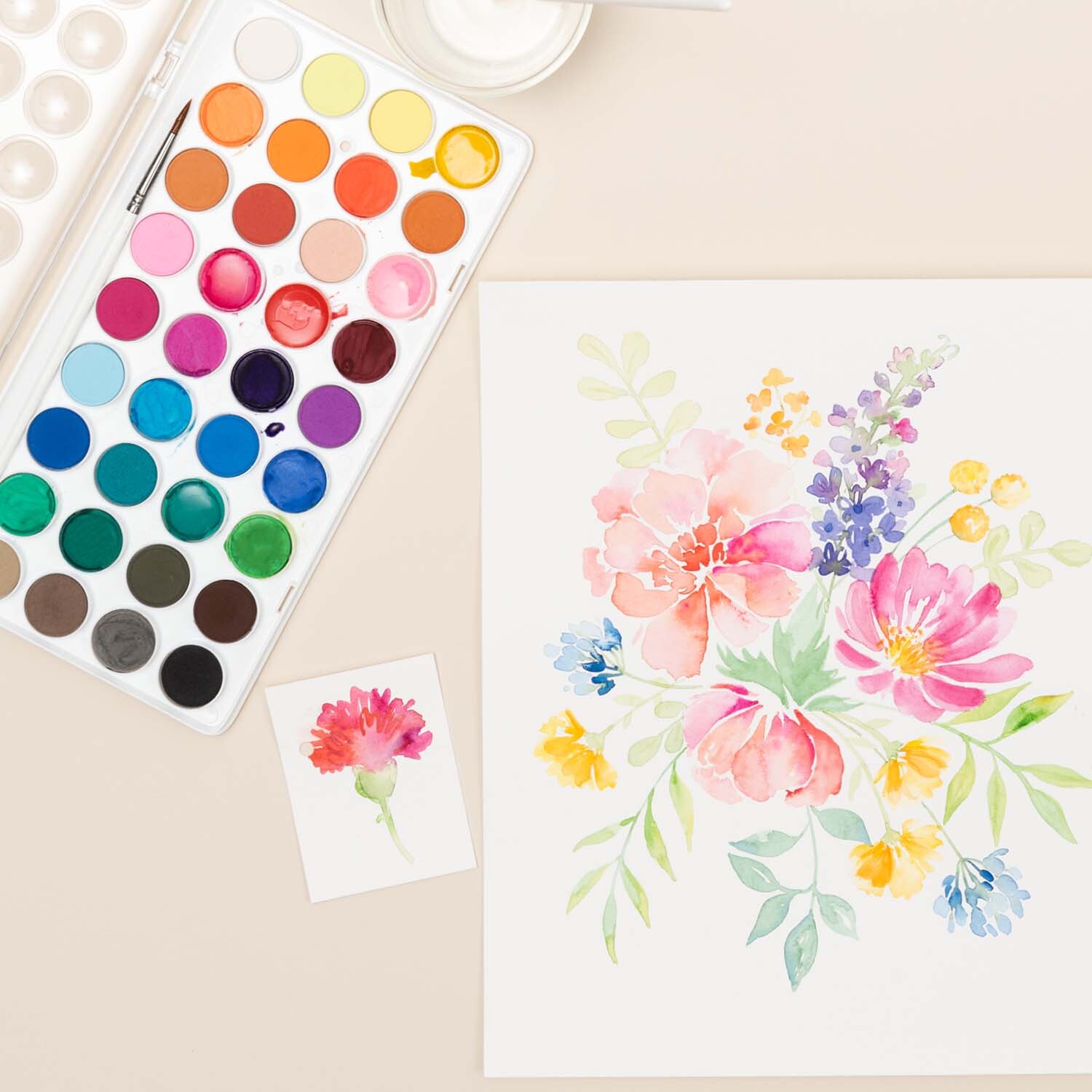 Anleitung Floral Watercoloring: Aquarellfarben-Set mit Blumenmotiv auf hellem Hintergrund.