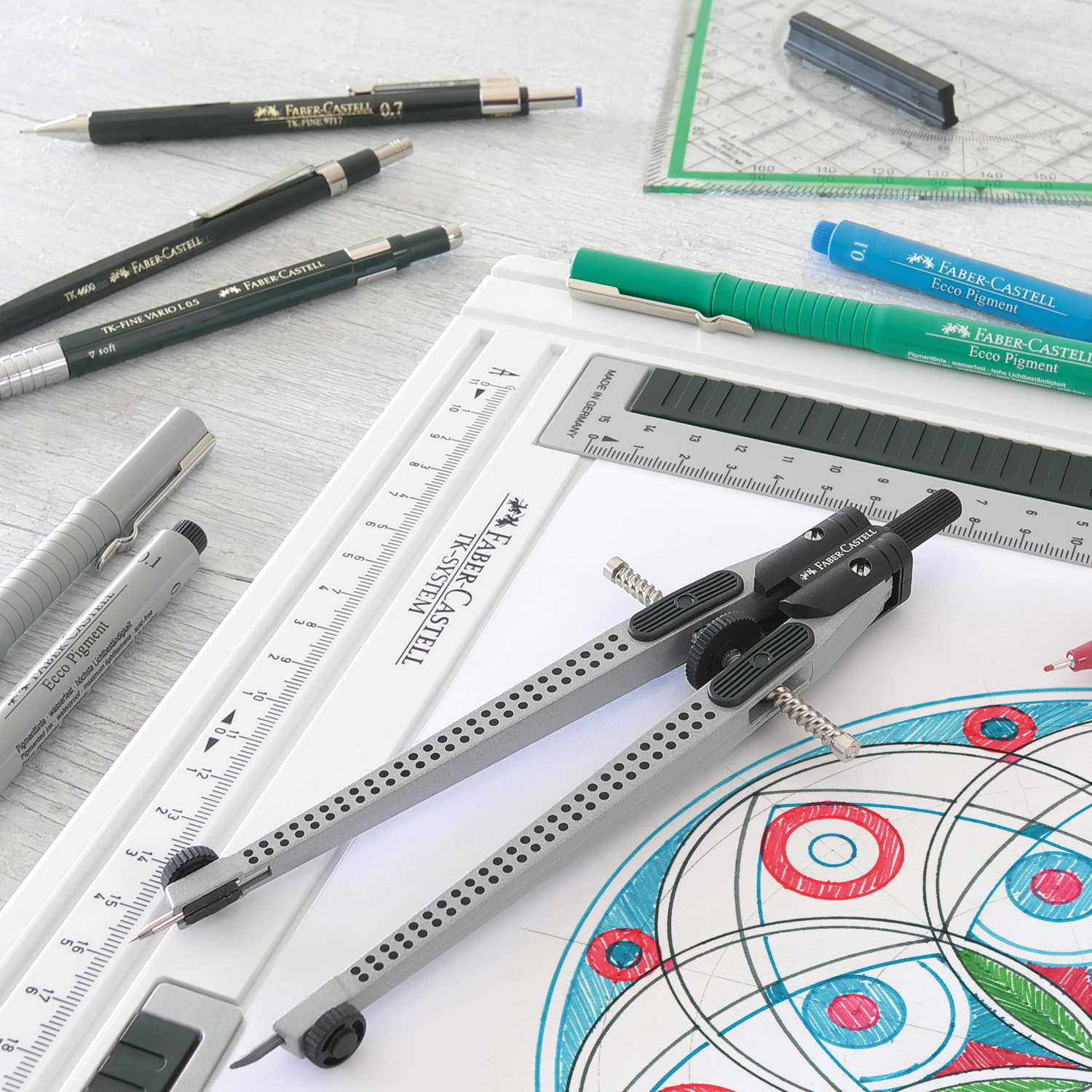 TK-Fine 9713 Druckbleistift von Faber Castell auf einem Schreibtisch mit Zeichenwerkzeugen und geometrischen Zeichnungen.