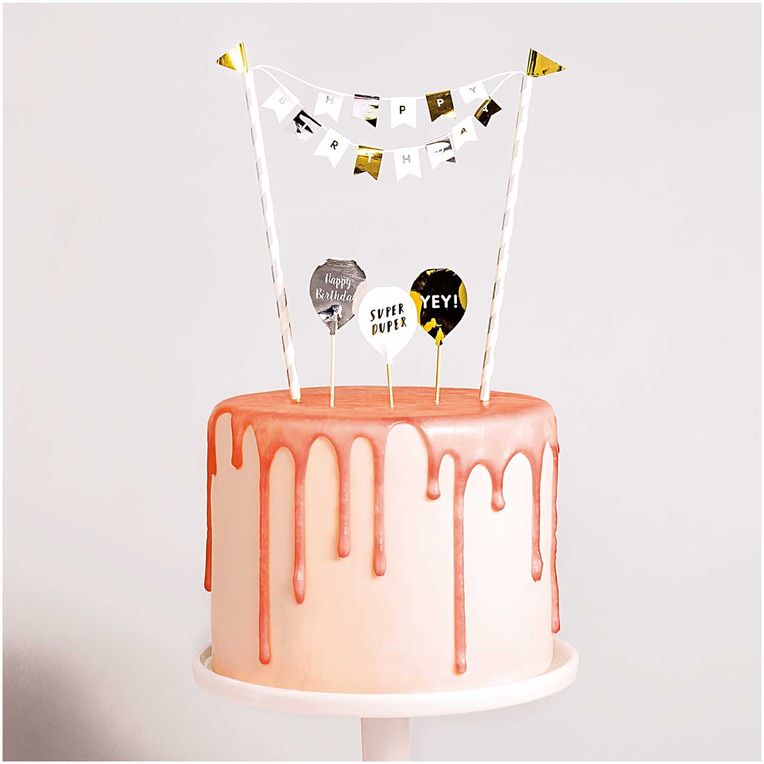 Kuchendekoration Happy Birthday classic: Eine stilvolle Torte mit rosa Glasur und festlichen Dekorationen von Rico Design.