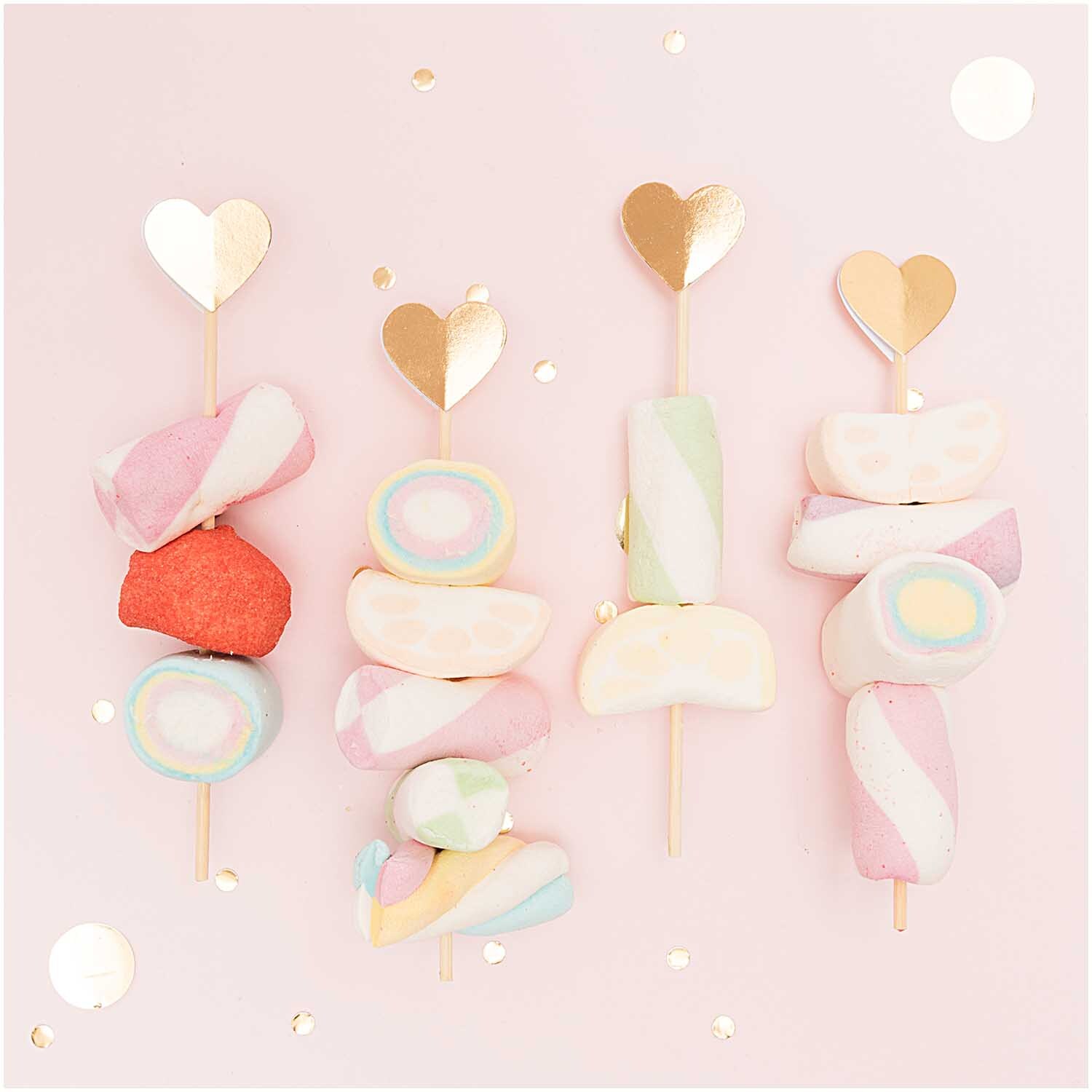 Picker Herz gold 15cm 24 Stück von Rico Design: Goldene Herz-Picker dekorieren bunte Marshmallow-Spieße auf rosa Hintergrund.