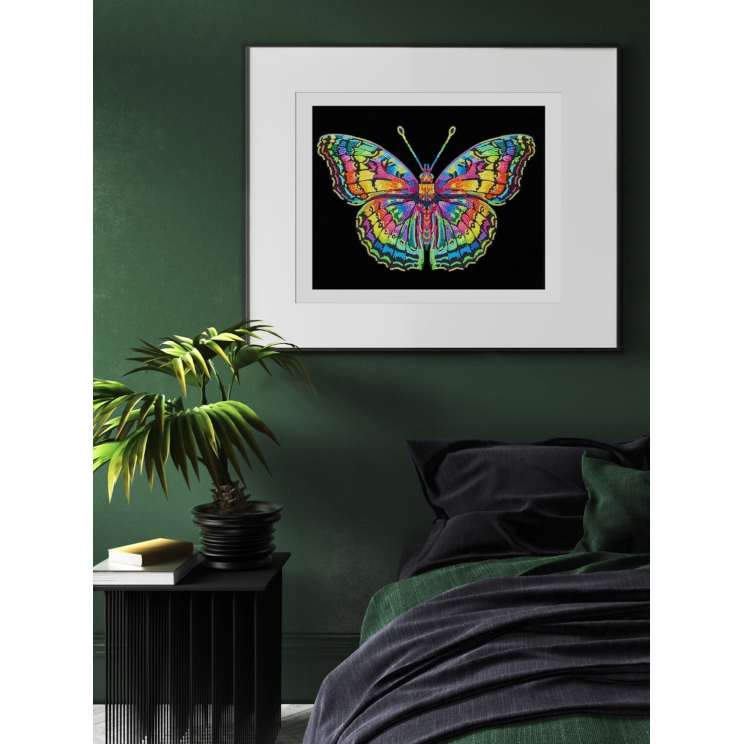 Diamond Painting Neon Schmetterling: Buntes Kunstwerk in weißem Rahmen, aufgehängt an grüner Wand über einem Bett.
