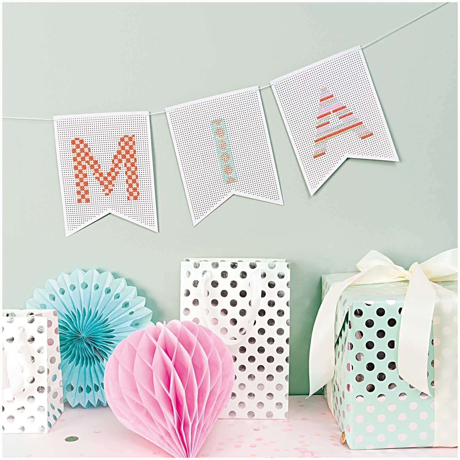 Paper Poetry Geschenkpapier mit weißen und silbernen Punkten, dekoriert mit Geschenken und Partydekorationen.