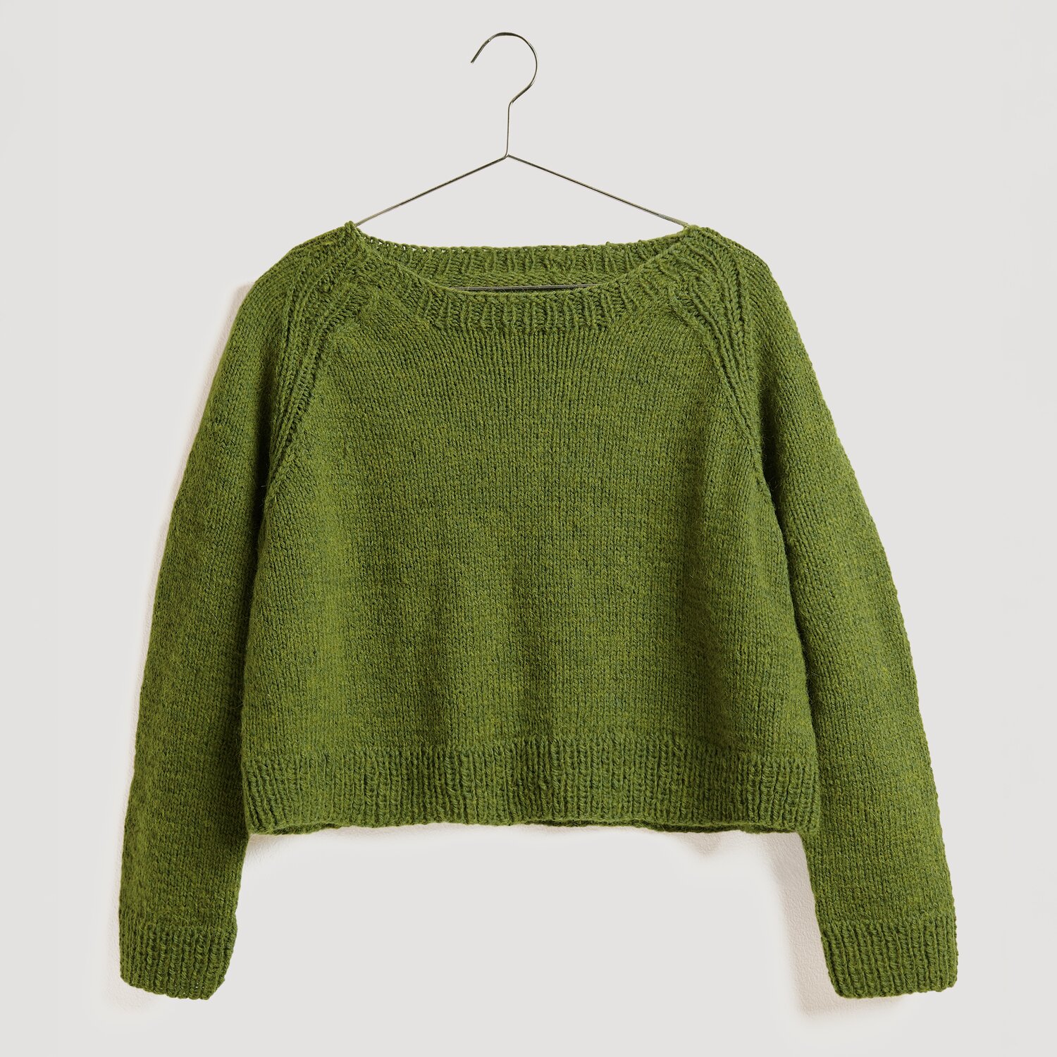 Gestrickter Pullover in Grün auf Bügel kurz