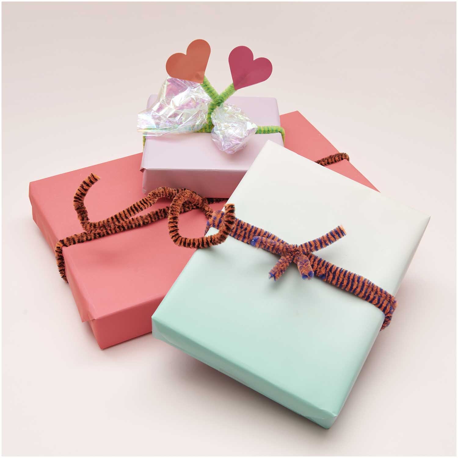 Chenilledraht-Mix 50cm 10 Stück Streifen Mix: Drei bunt verpackte Geschenke mit dekorativen Chenilledrähten und Herzverzierungen.