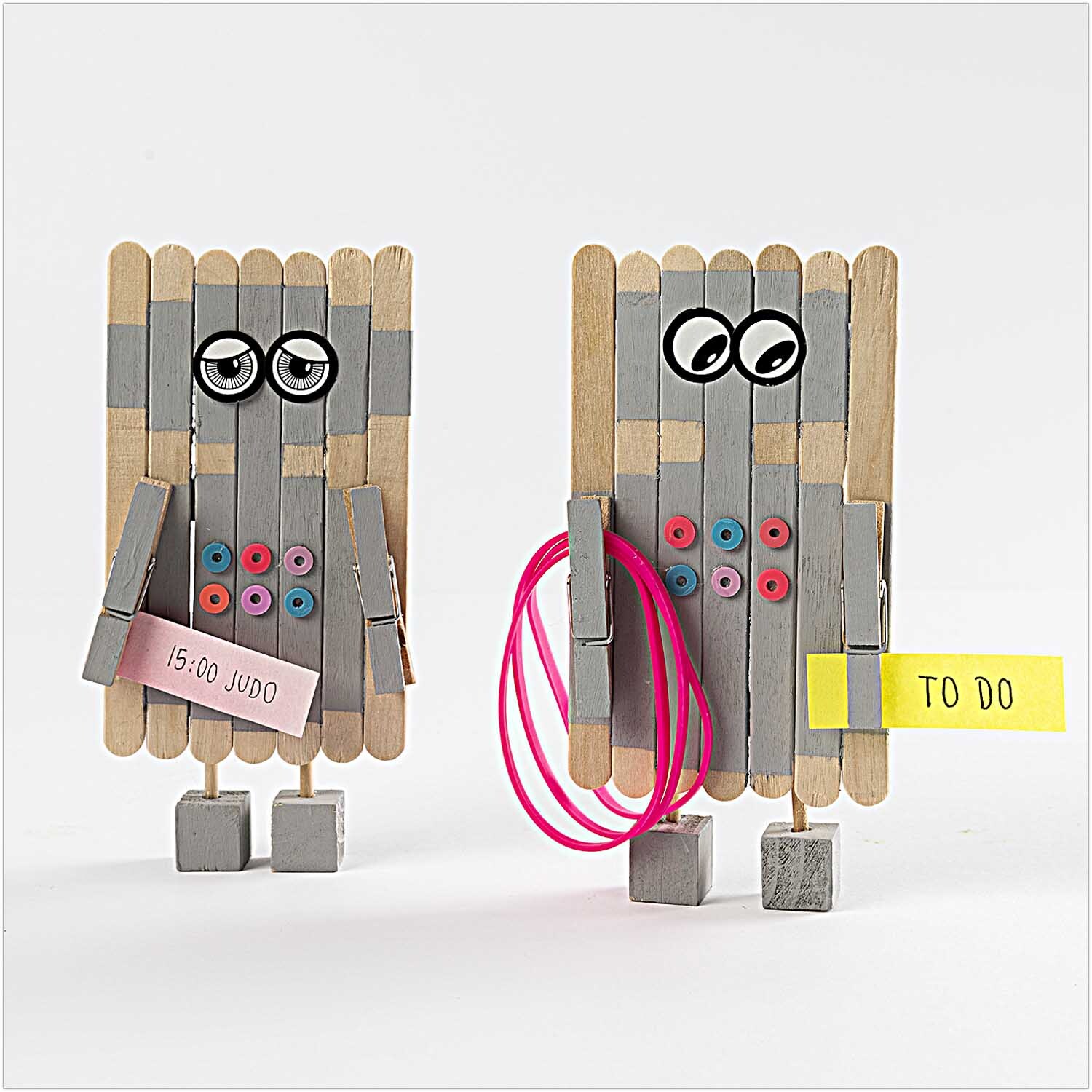 DIY-Holzbastelset: Zwei kreative Figuren aus Holzstäbchen mit Augen und farbigen Details. Ideal für Bastelprojekte.