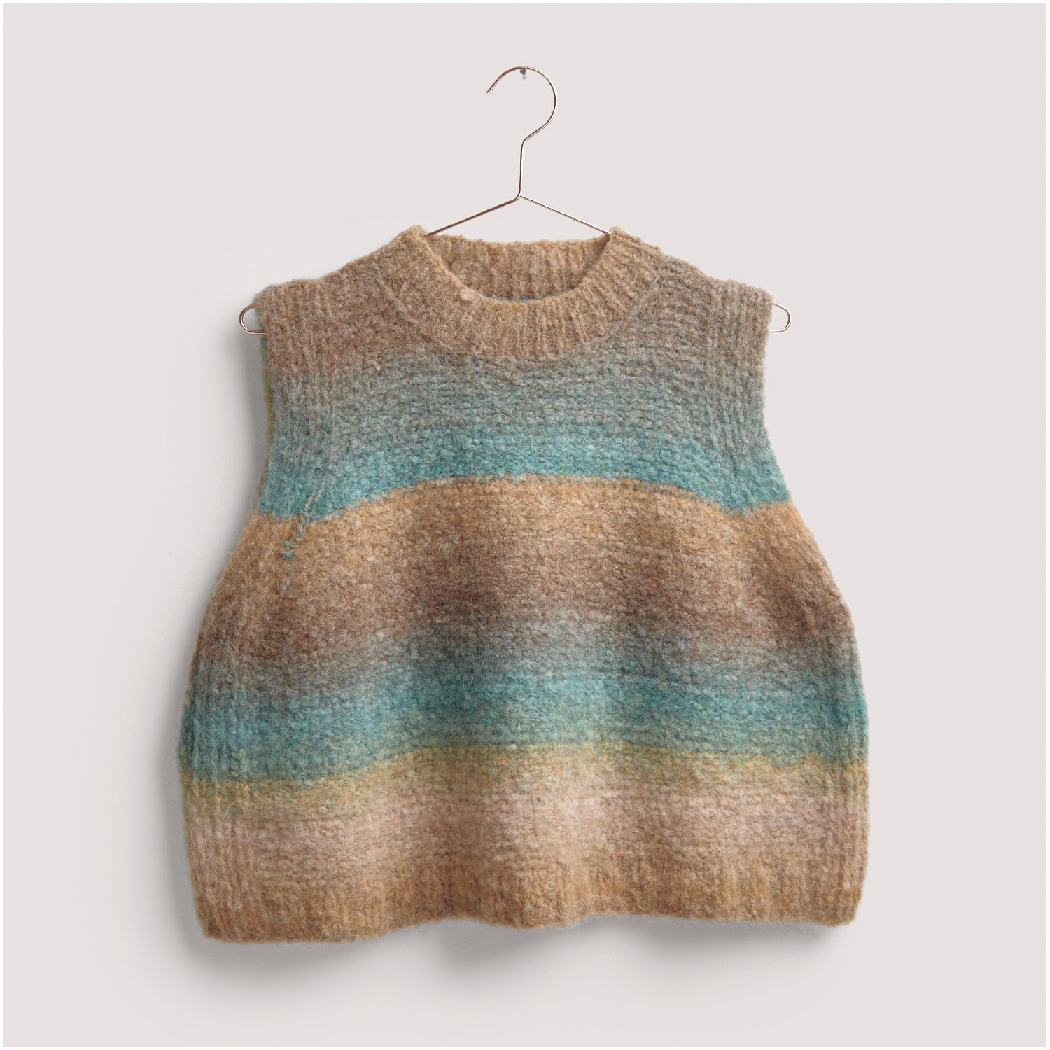 Strickset Pullunder Modell 09: Beigefarbener Pullunder mit blauen und grünen Streifen, hängend an einem Kleiderbügel.