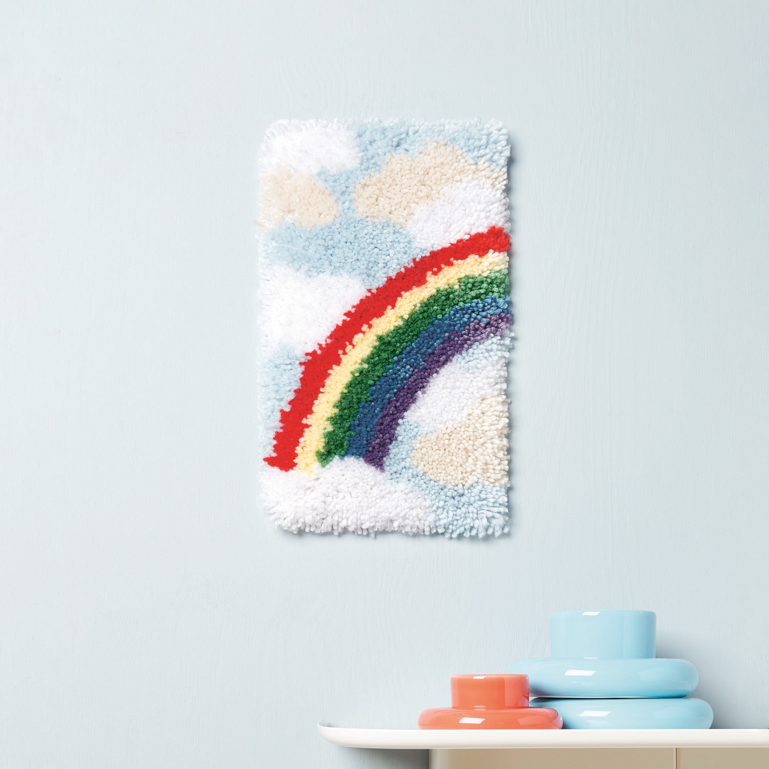 Rico Hooki Hooki Knüpfgarn zeigt einen bunten Regenbogen auf blauem Hintergrund, ideal für kreative Projekte.