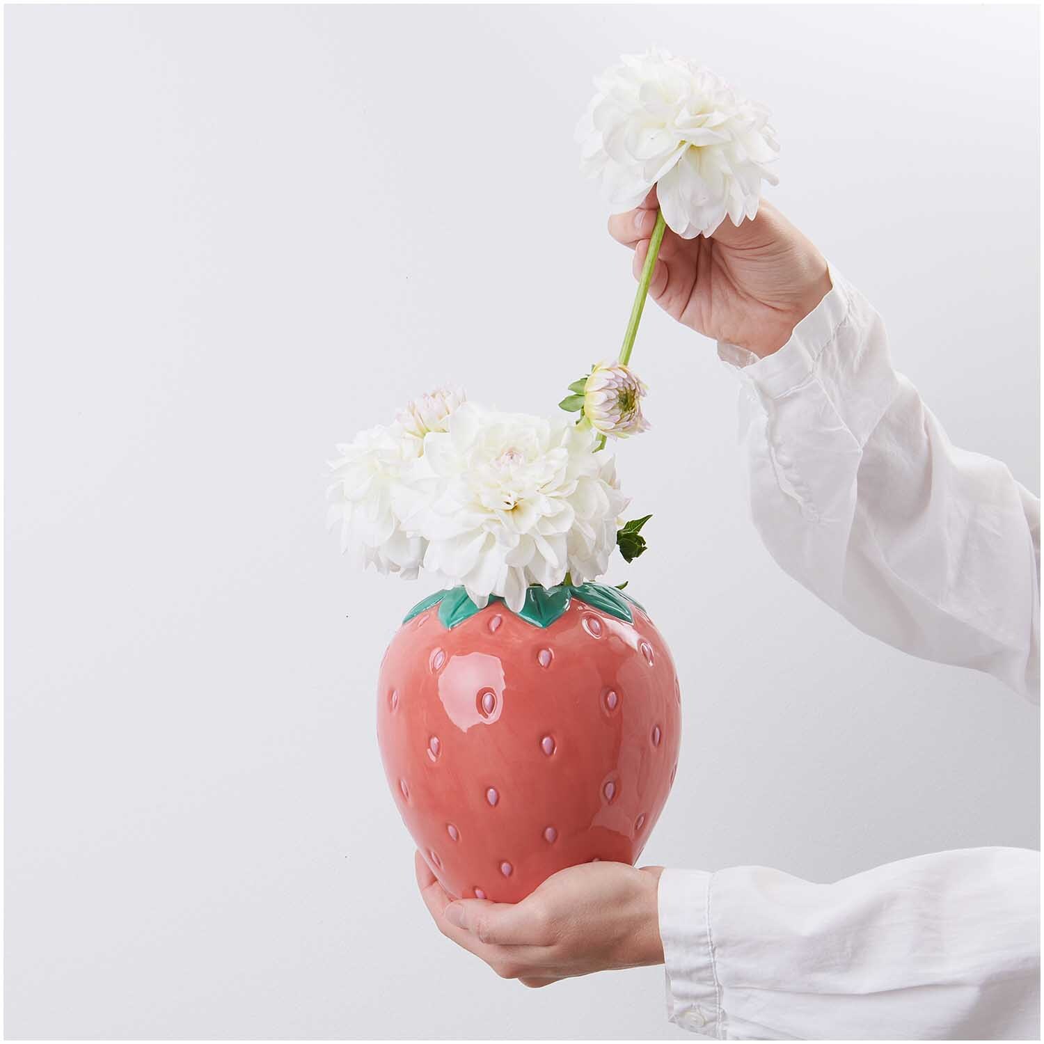 Keramik Vase Erdbeere Ø14cm von Rico Design, geformt wie eine Erdbeere, mit weißen Blumen dekoriert.
