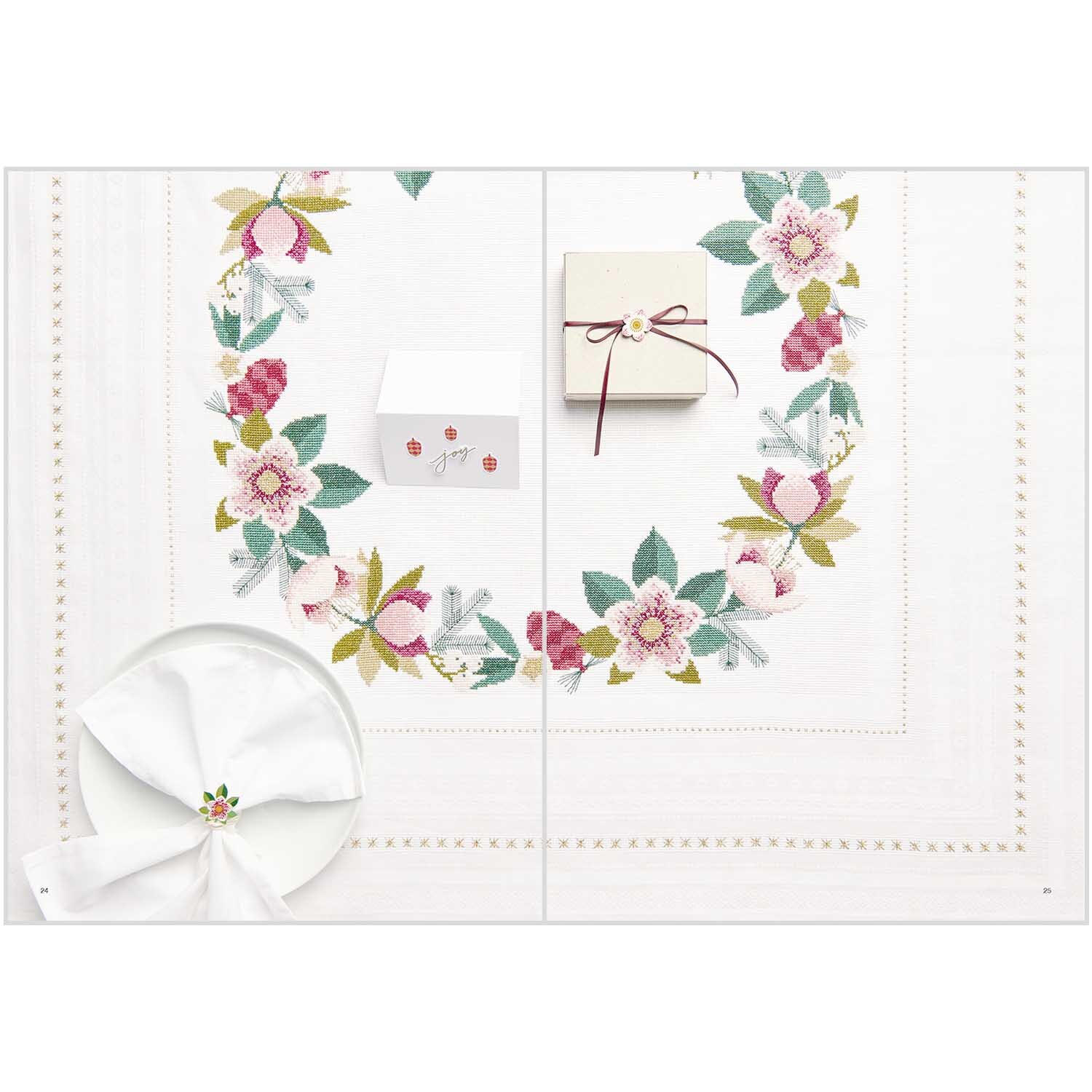 Stickbuch Christmas Joy Nr. 182 zeigt ein festliches Tischset mit floralen Stickereien und Geschenken. Ideal für weihnachtliche Dekorationen.
