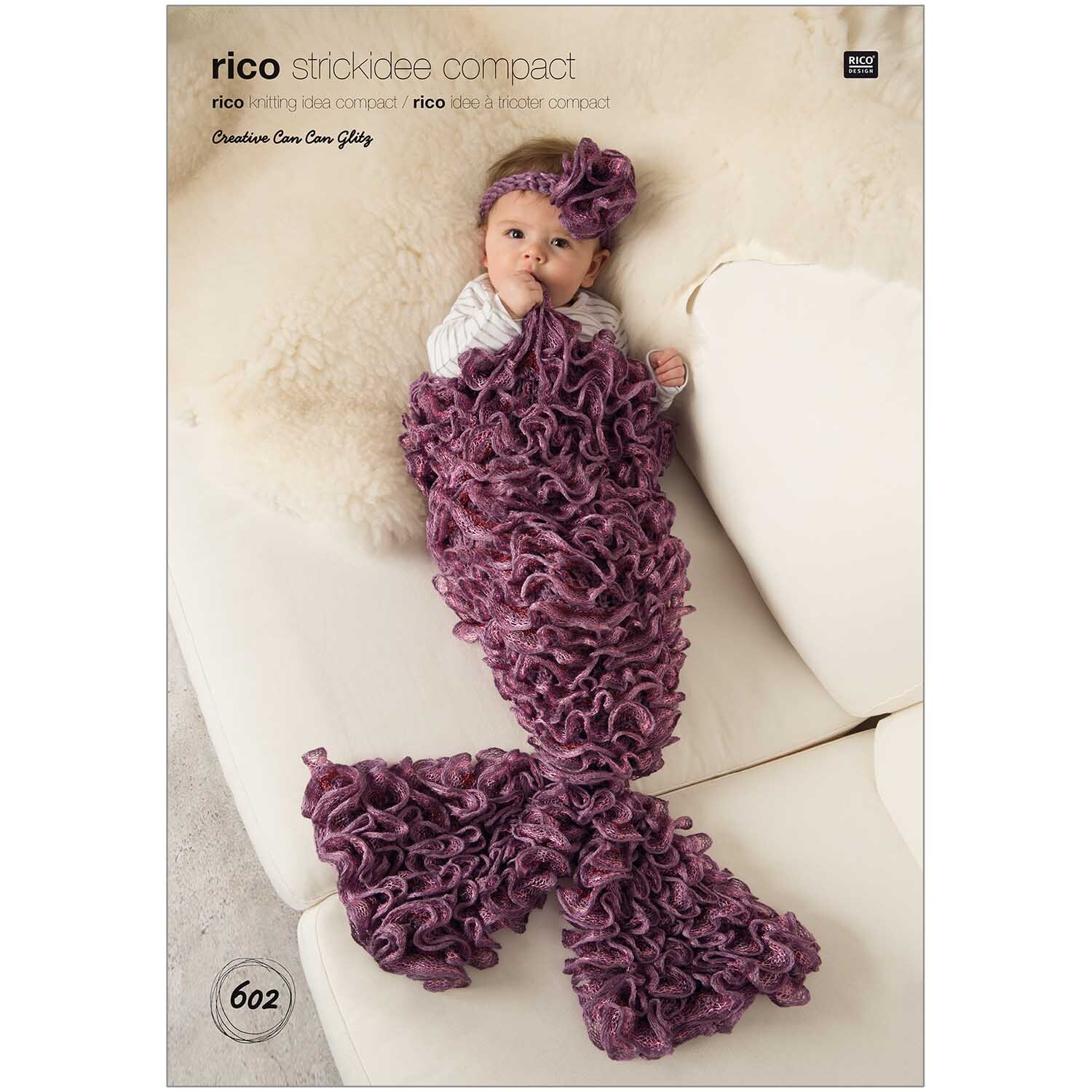 Strickidee compact Nr.602 Mermaid Baby: Ein Baby in einem lila Meerjungfrau-Strickanzug von Rico Design auf einem cremefarbenen Sofa.