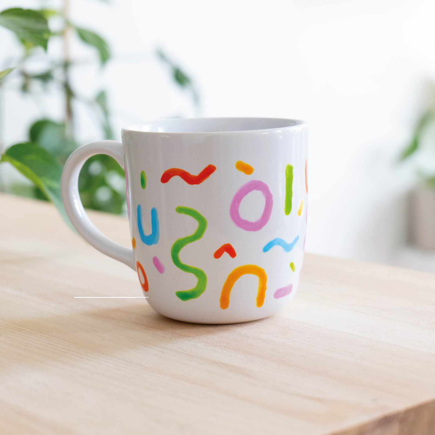Porcelain & Glass Starterset matt: Weiße Tasse mit bunten Symbolen, ideal für kreative Designs.