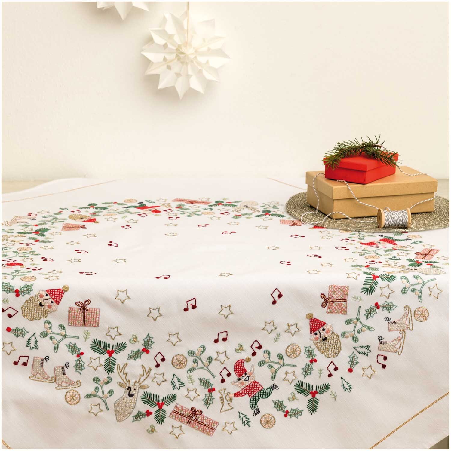Stickpackung Tischdecke Wichtel 90x90cm mit weihnachtlichen Motiven, dekoriert mit Geschenken und Sternen, von Rico Design.