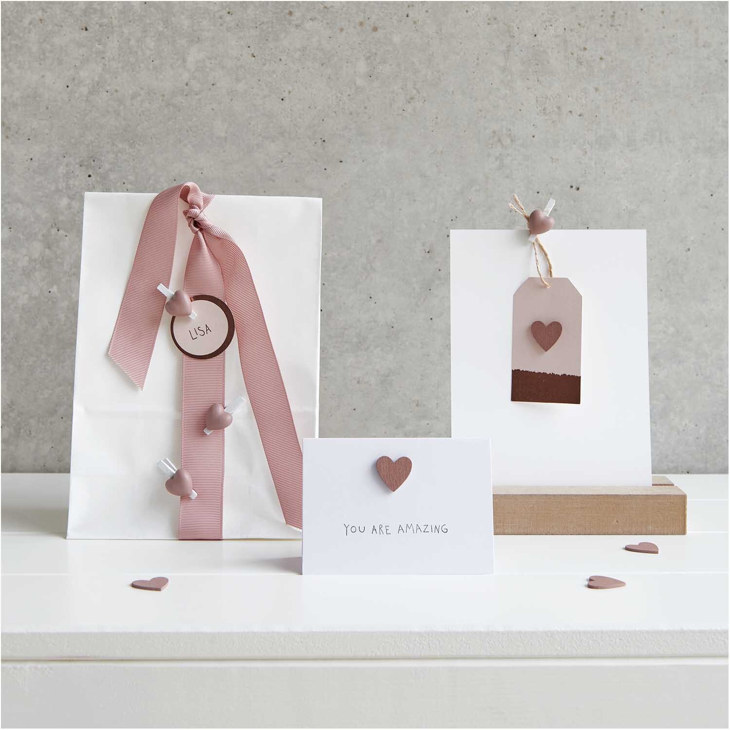 Holzsticker Herz 48 Stück: Dekorative roségoldene Herzsticker von Rico Design auf Geschenktüten und Karten. Ideal für kreative Bastelprojekte.
