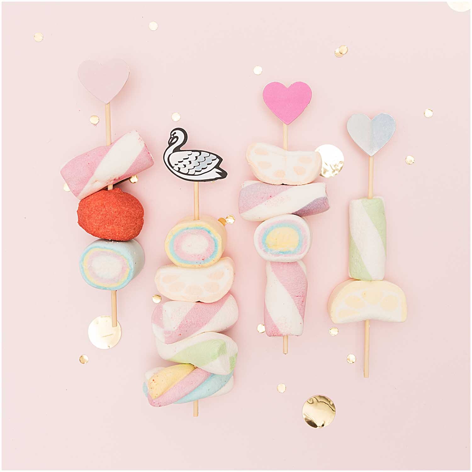 Picker Mix Schwan irisierend 15cm 24 Stück: Bunte Marshmallow-Spieße mit Herz- und Schwan-Dekoration auf rosa Hintergrund.