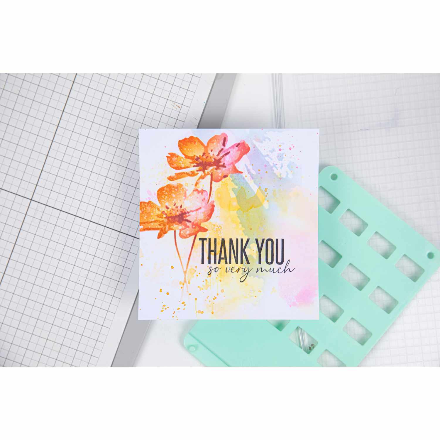 Layered Stencils Flowers von Olivia Rose zeigt ein farbenfrohes Blumenmotiv mit "Thank You"-Text auf einem Aquarellhintergrund.