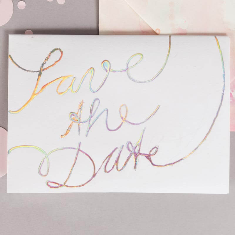 Transferfolie 9x15cm 6 Blatt: Elegante Karte mit "Save the Date" in schimmernden Farben auf grauem Hintergrund. Ideal für kreative Designs.