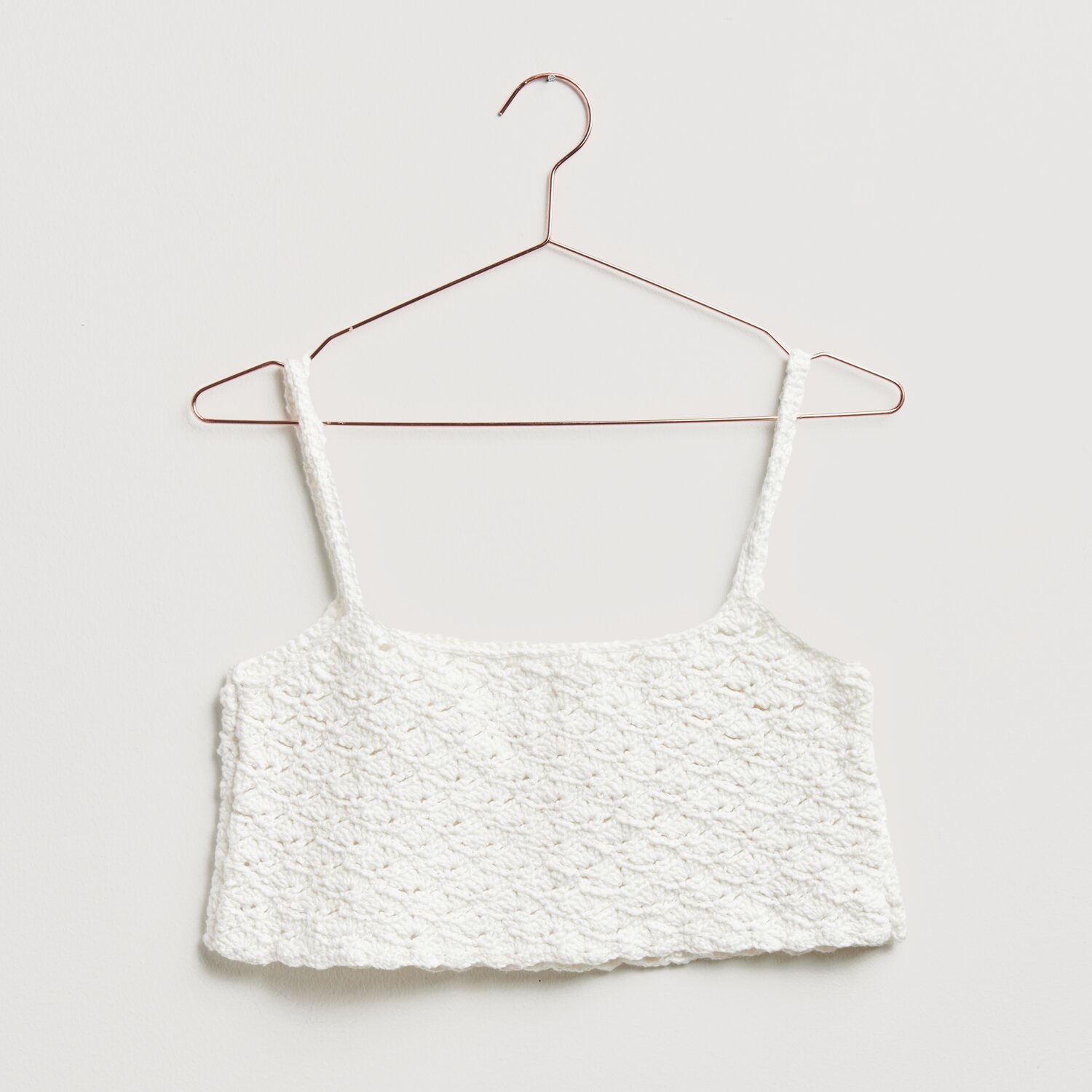 Häkelset Top Modell 27 aus Made by Me No. 20: Weißes, gehäkeltes Top auf einem Kleiderbügel. Ideal für Frühjahr-Sommer.