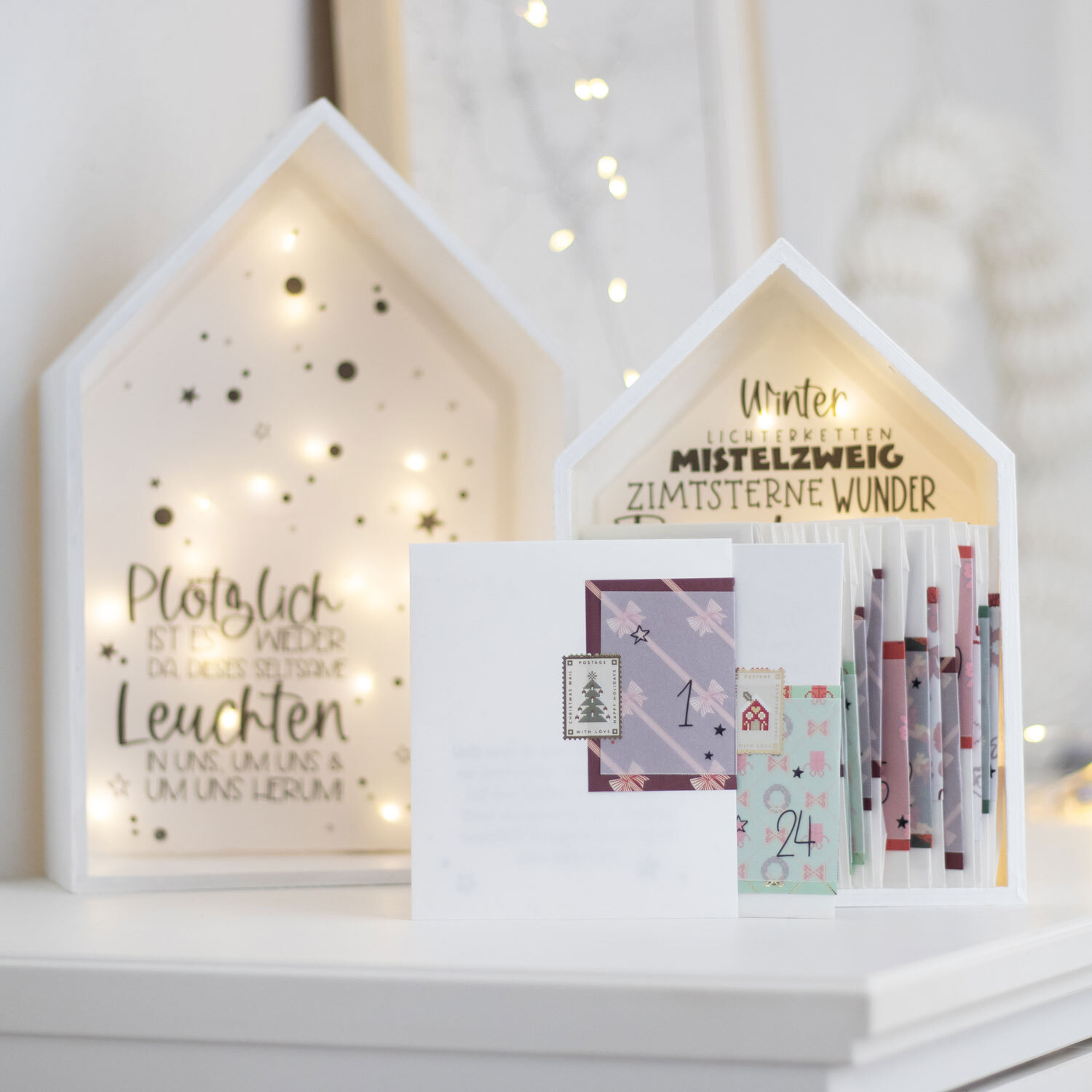 Inspiration Achtsamkeits-Adventskalender: Weißer Kalender mit Lichtern und dekorativen Karten.