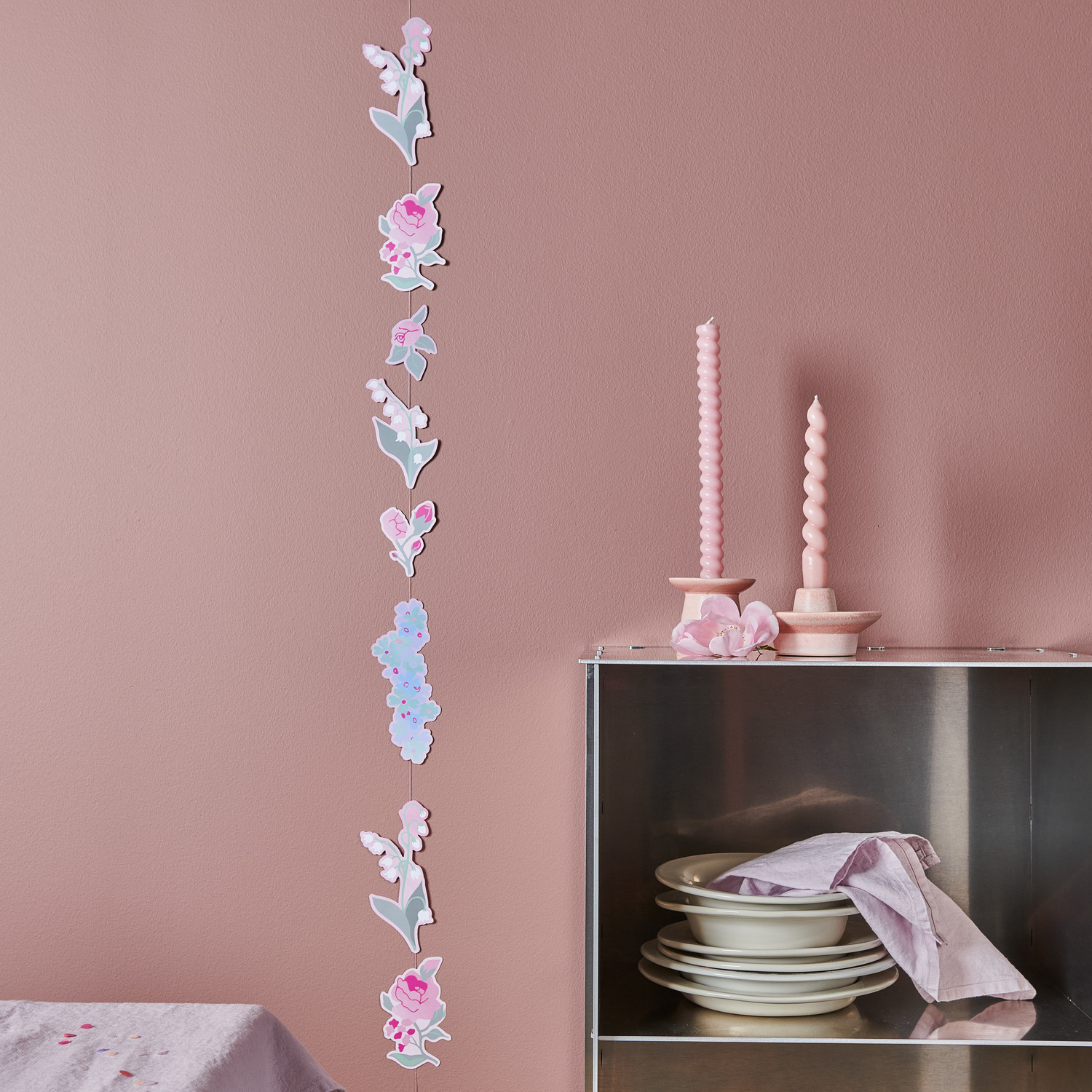 Paper Poetry Genähte Girlande Vergissmeinnicht dekoriert eine Wand in zarten Pastelltönen. Ideal für stilvolle Raumgestaltung.