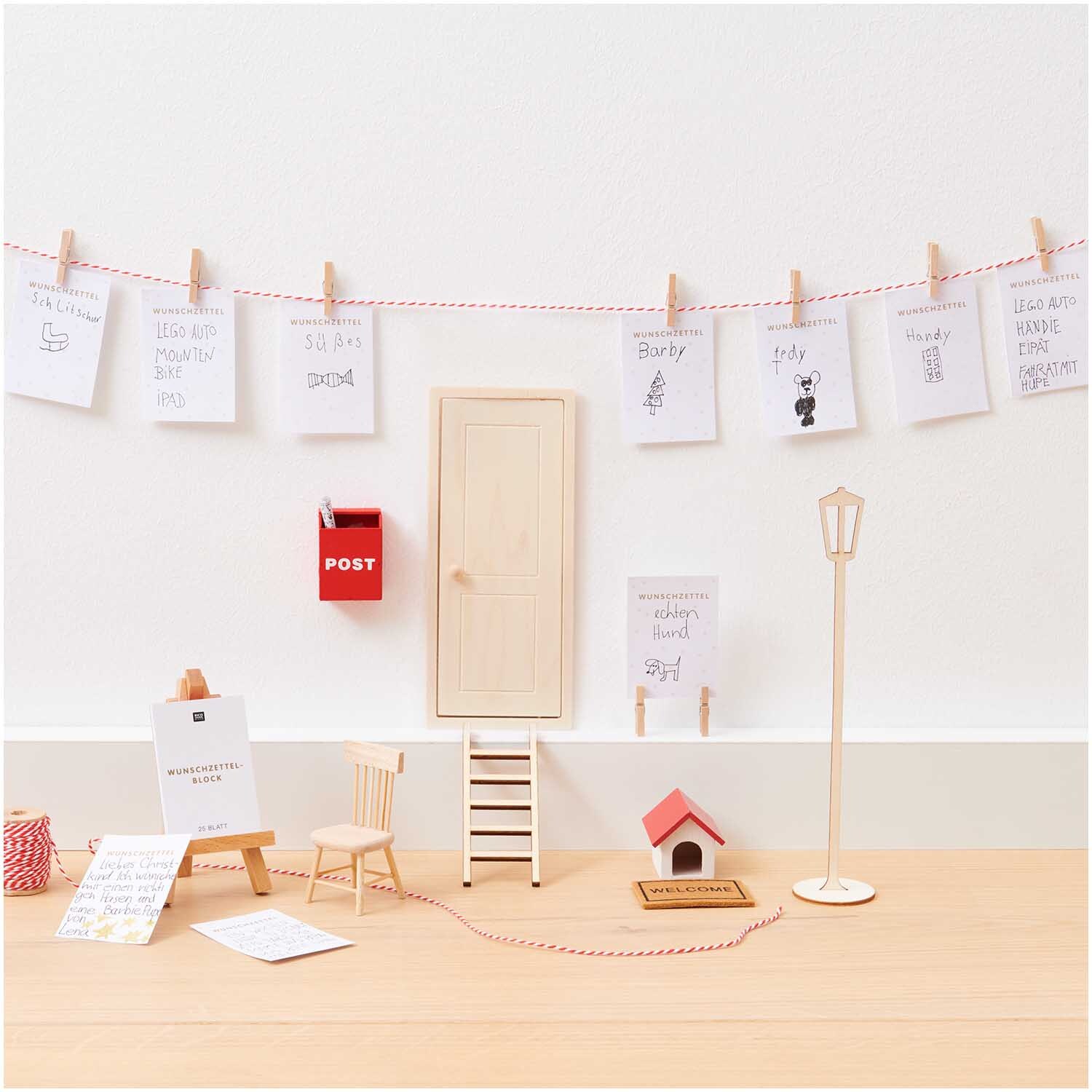 Miniatur Leiter 5x12cm vor einer weißen Wand mit kleinen Möbeln und Dekorationen von Rico Design.