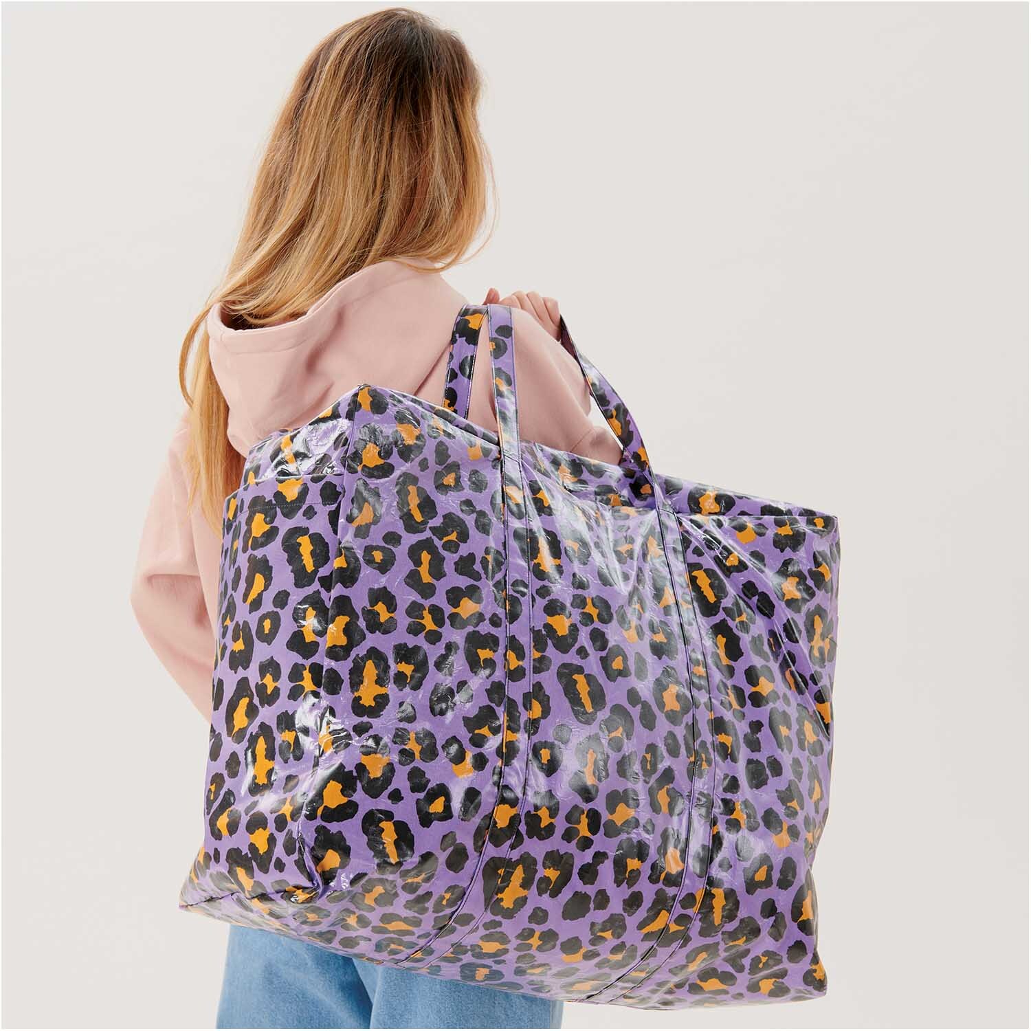 Stoffabschnitt PVC-Stoff Glossy Acid Leo lila 25x70cm: Frau mit großer, lila Leopardenmuster-Tasche von Rico Design.