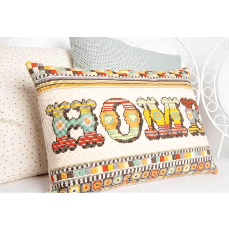 Kissen handbestickt Home 50x35cm mit buntem Muster auf einem weißen Bett, von Rico Design.