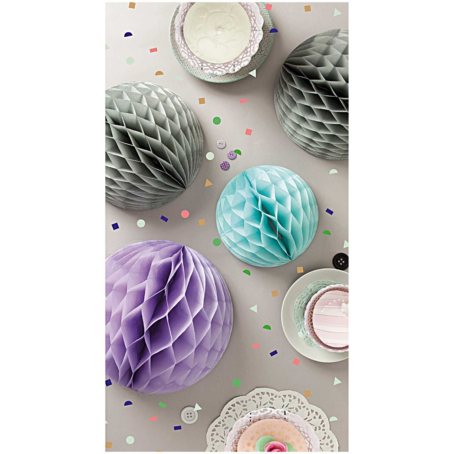 Wabenpapier Bälle pastell 3 Stück von Rico Design in verschiedenen Farben, dekorativ arrangiert auf einem Tisch mit Konfetti.