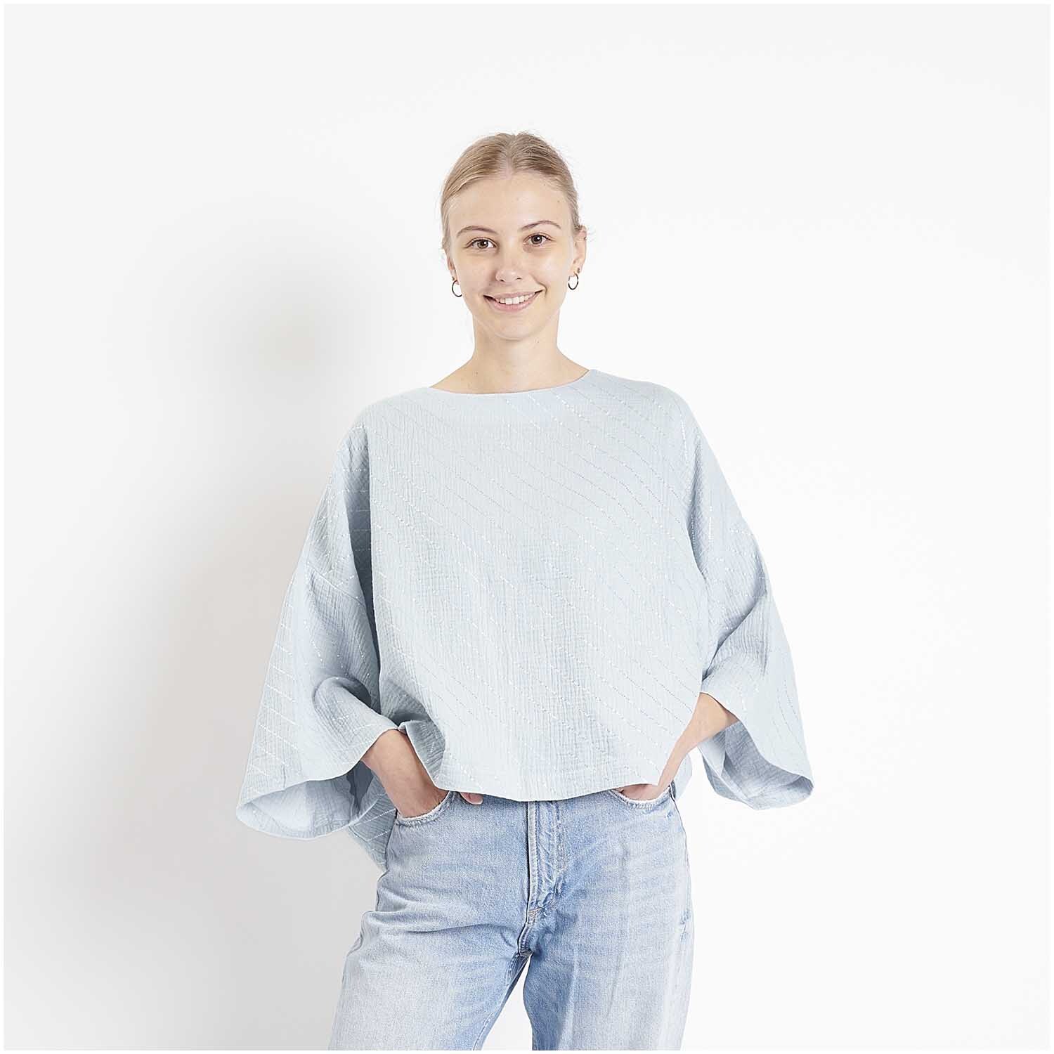 Meterware Krinkelmusselin Streifen Hellblau: Frau trägt hellblaues Oberteil aus Rico Design Stoff, lässig und modern.