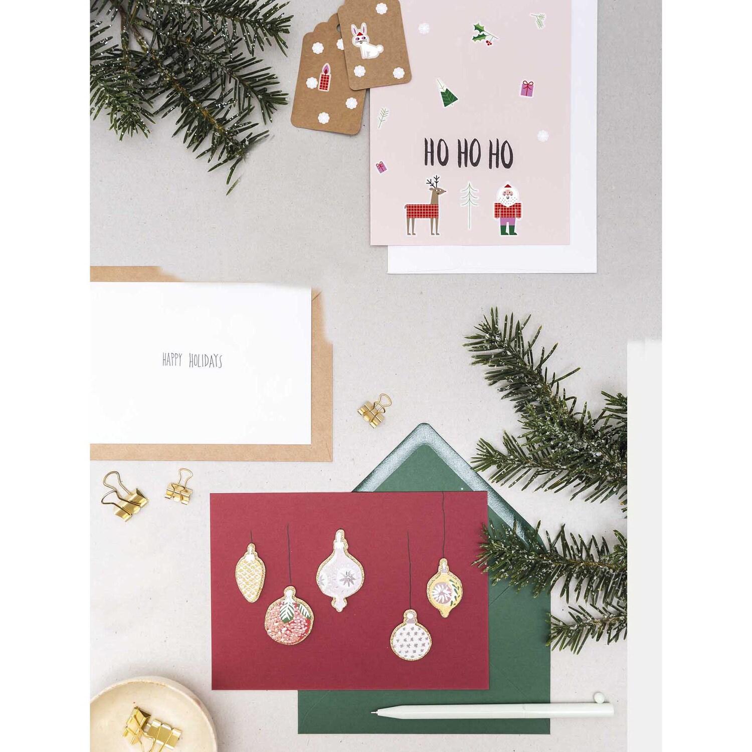 Paper Poetry Gelsticker Weihnachtsmann 1 Blatt: Mehrfarbige Weihnachtskarten mit Tannenzweigen und Dekorationen auf einem Tisch arrangiert.