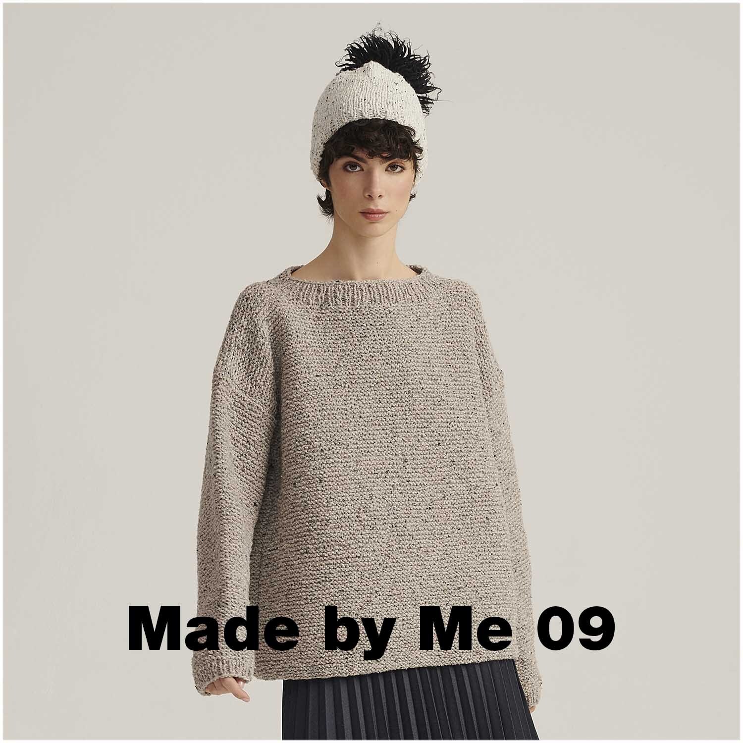 Fashion Modern Tweed aran: Frau trägt gestrickten Pullover in Naturtönen, kombiniert mit schwarzem Rock und Mütze.