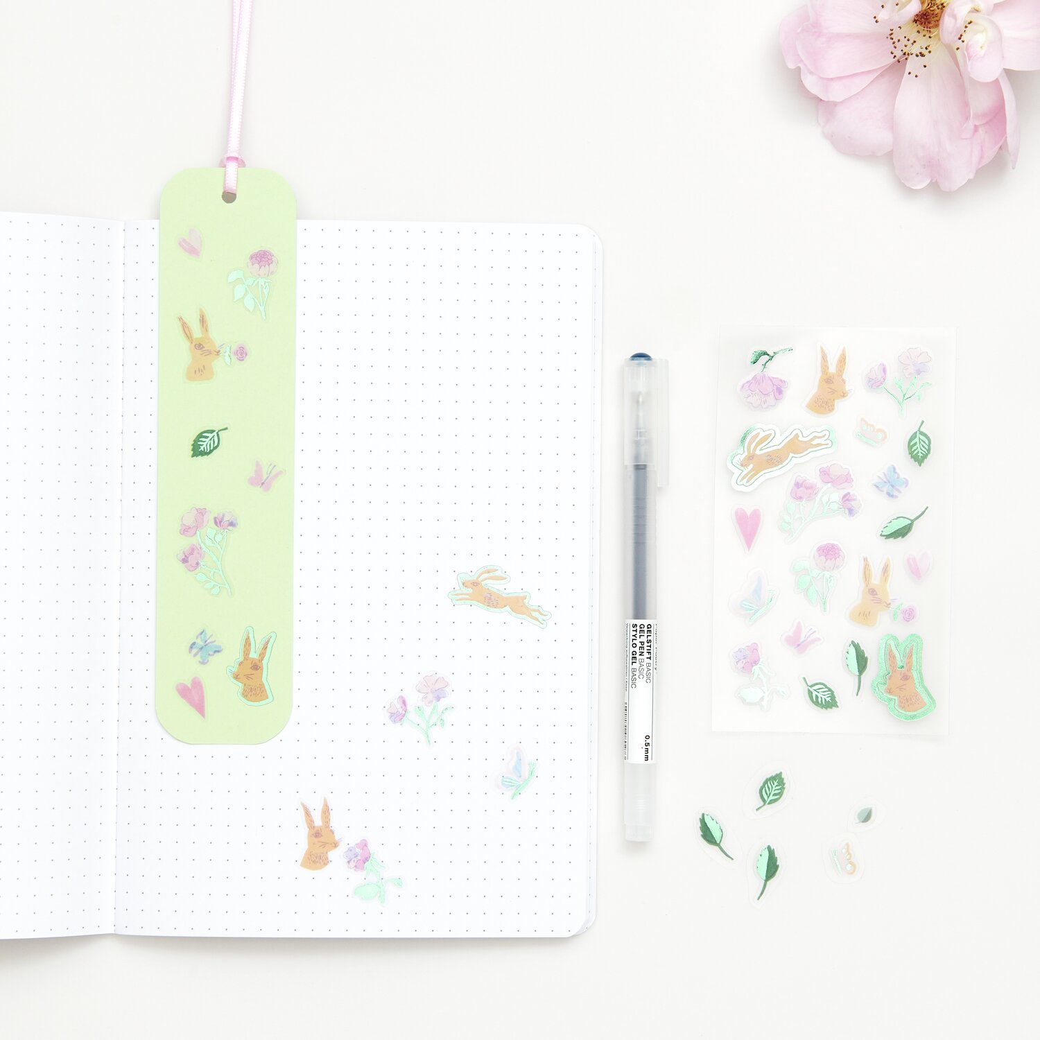 Paper Poetry Foliensticker mit Blumen und Hasen auf einem Notizbuch, begleitet von einem Stift.