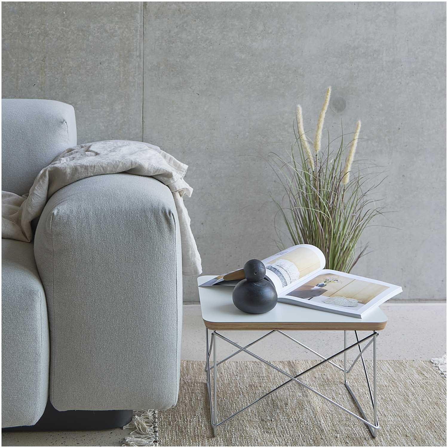 Dünengras im Topf 64cm neben einem grauen Sofa und einem modernen Tisch mit Dekorationen.