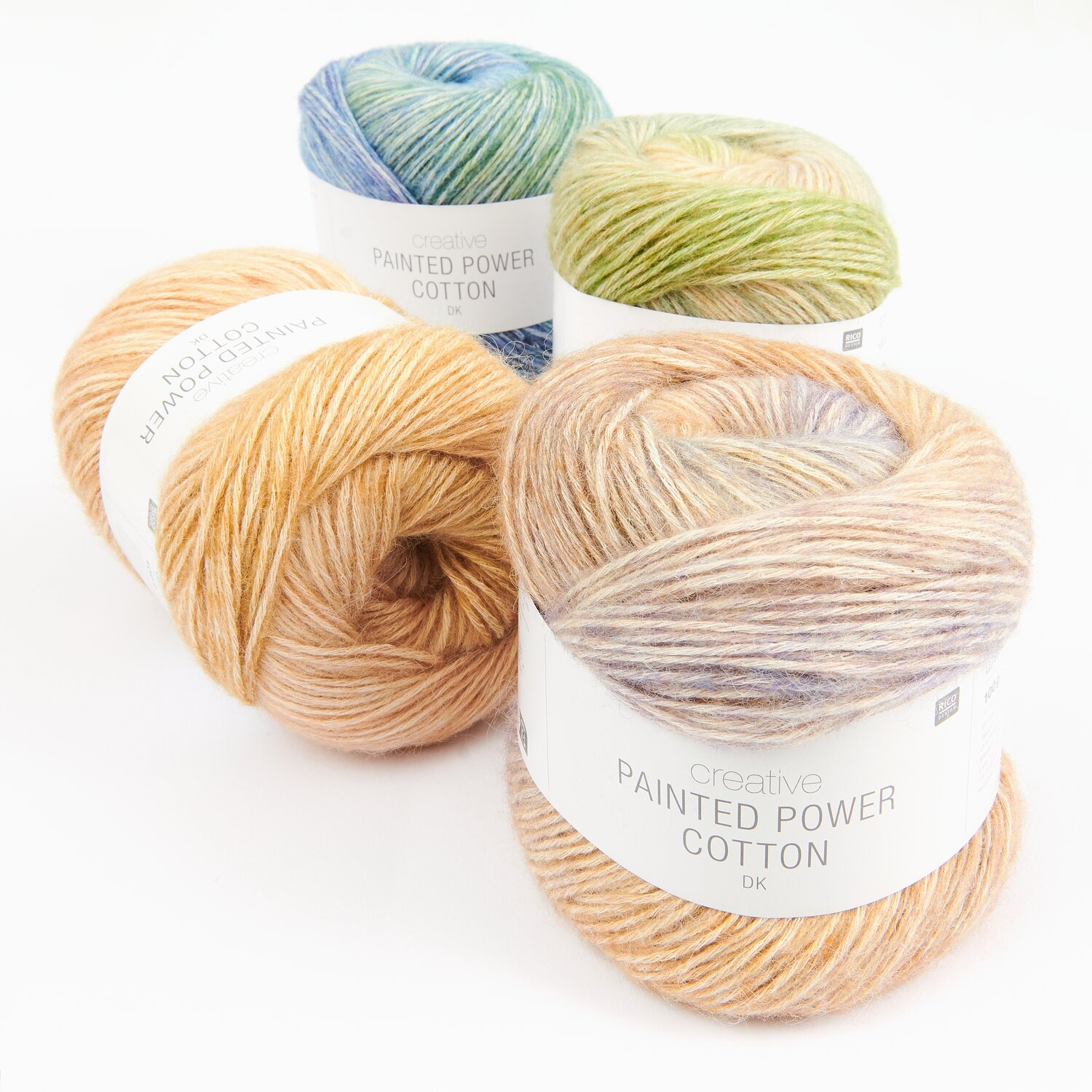 Creative Painted Power Cotton dk Sortiment II zeigt vier bunte Garnknäuel in Pastelltönen.