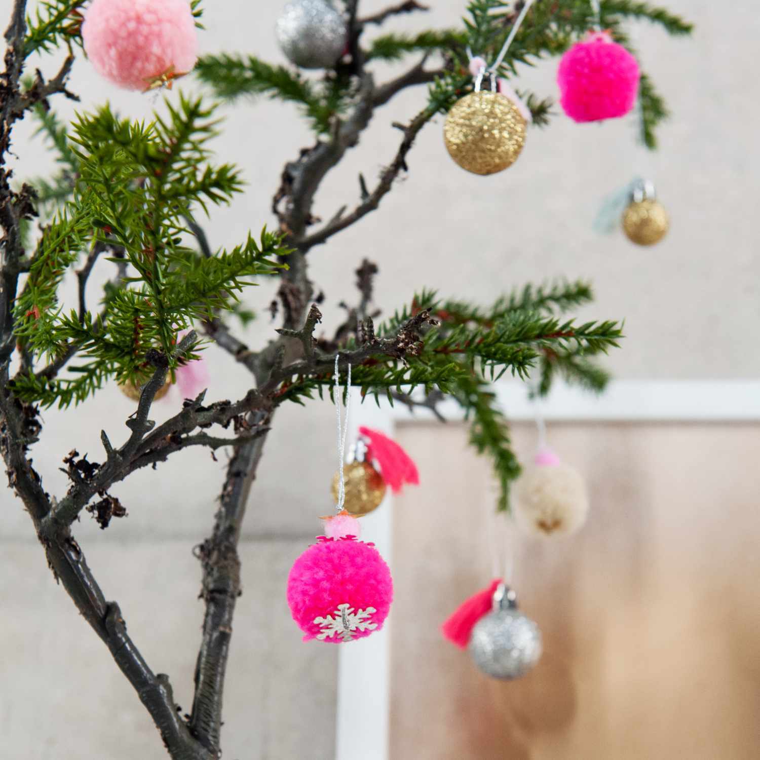 Pompon- und Kugel-Anhänger neon-pastell 6 Stück an einem Baum, dekorativ in verschiedenen Farben aufgehängt. Ideal für festliche Dekorationen.