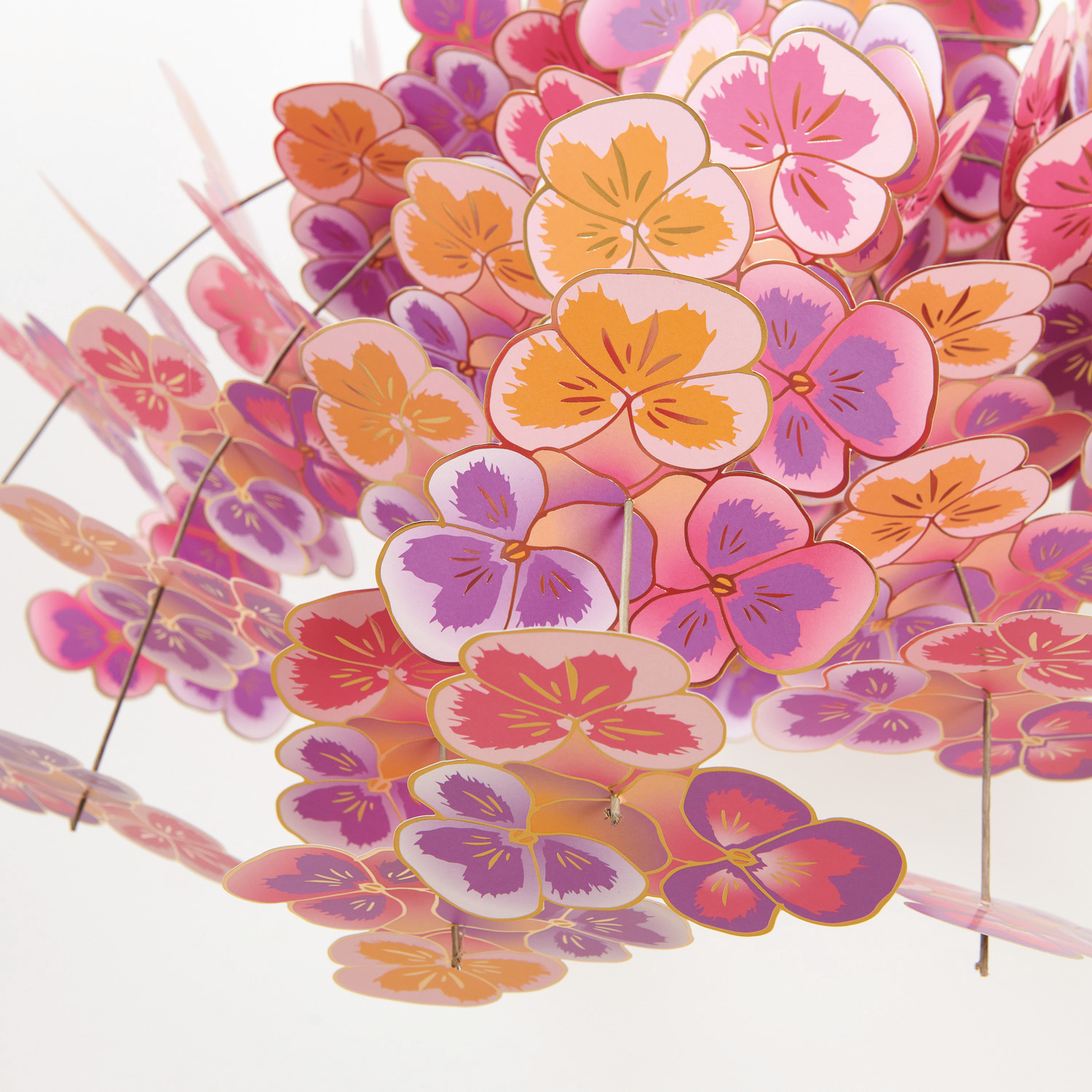 Bastelset Stiefmütterchen Fontäne von Rico Design: Bunte Papierblumen in Rosa, Lila und Orange, kunstvoll arrangiert.