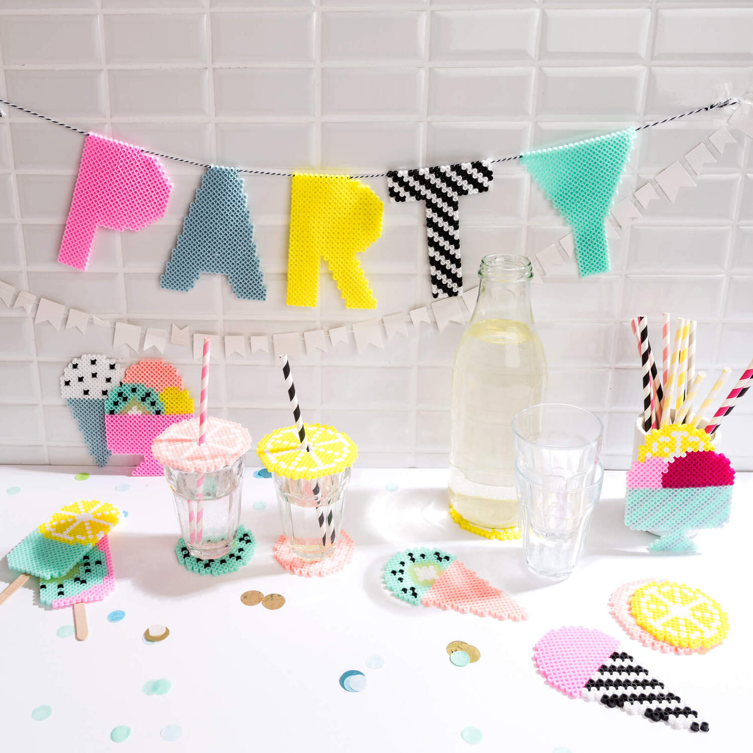 Bastelanleitung Bügelperlen Glasuntersetzer und -abdeckung: Bunte Party-Dekoration mit Bügelperlen, Gläsern und Getränken auf einem Tisch.