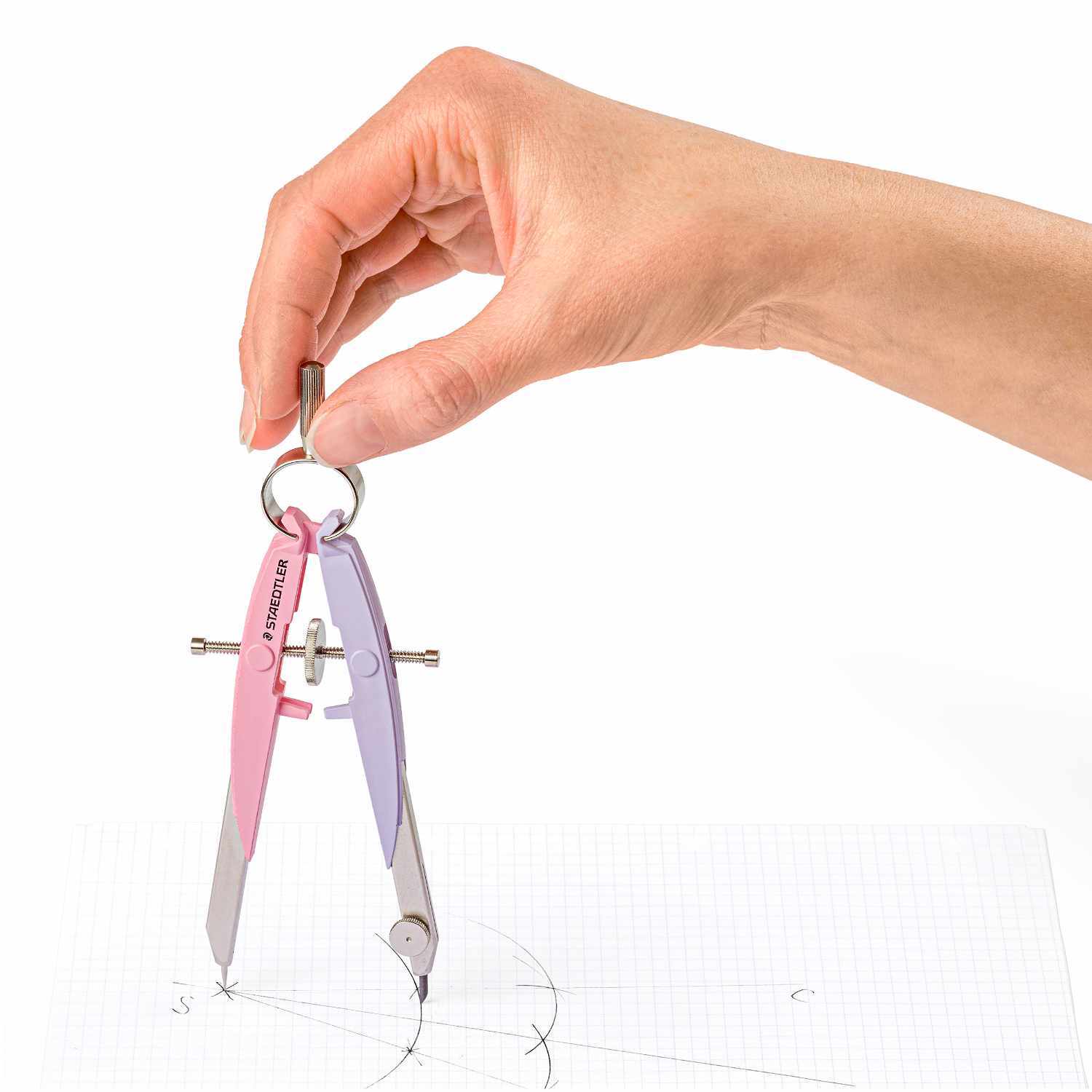 Mars Comfort Zirkel von Staedtler in Pink-Lavendel wird von einer Hand über Papier gehalten.