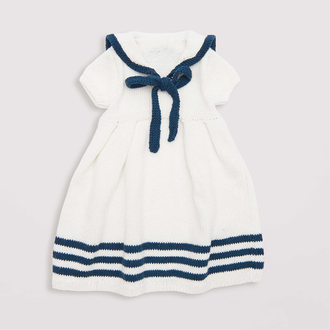Gestricktes Babykleid weiß mit dunkelblau: Modell 05 aus dem Heft Rico Baby 039