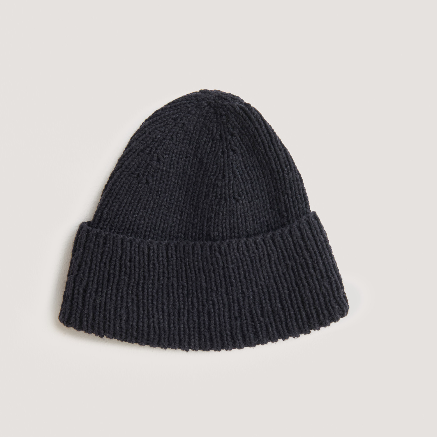 Vegan Cashmere Special: Schwarze Strickmütze aus weichem Material von Rico Design auf hellem Hintergrund.